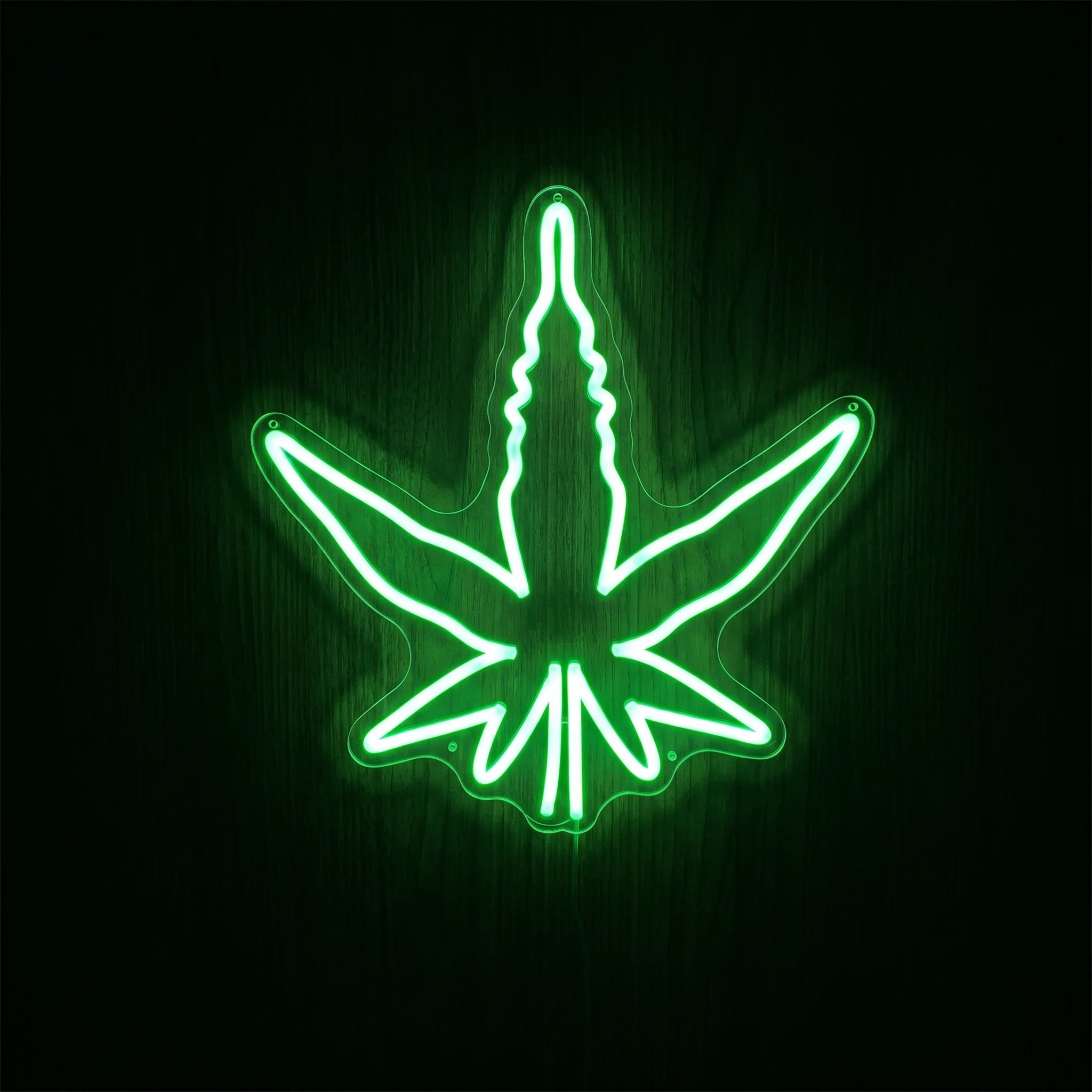 Classic green cannabis leaf LED neon sign on acrylic backing for cannabis wall dΓ©cor, dispensary display, or adult recreational interiors.