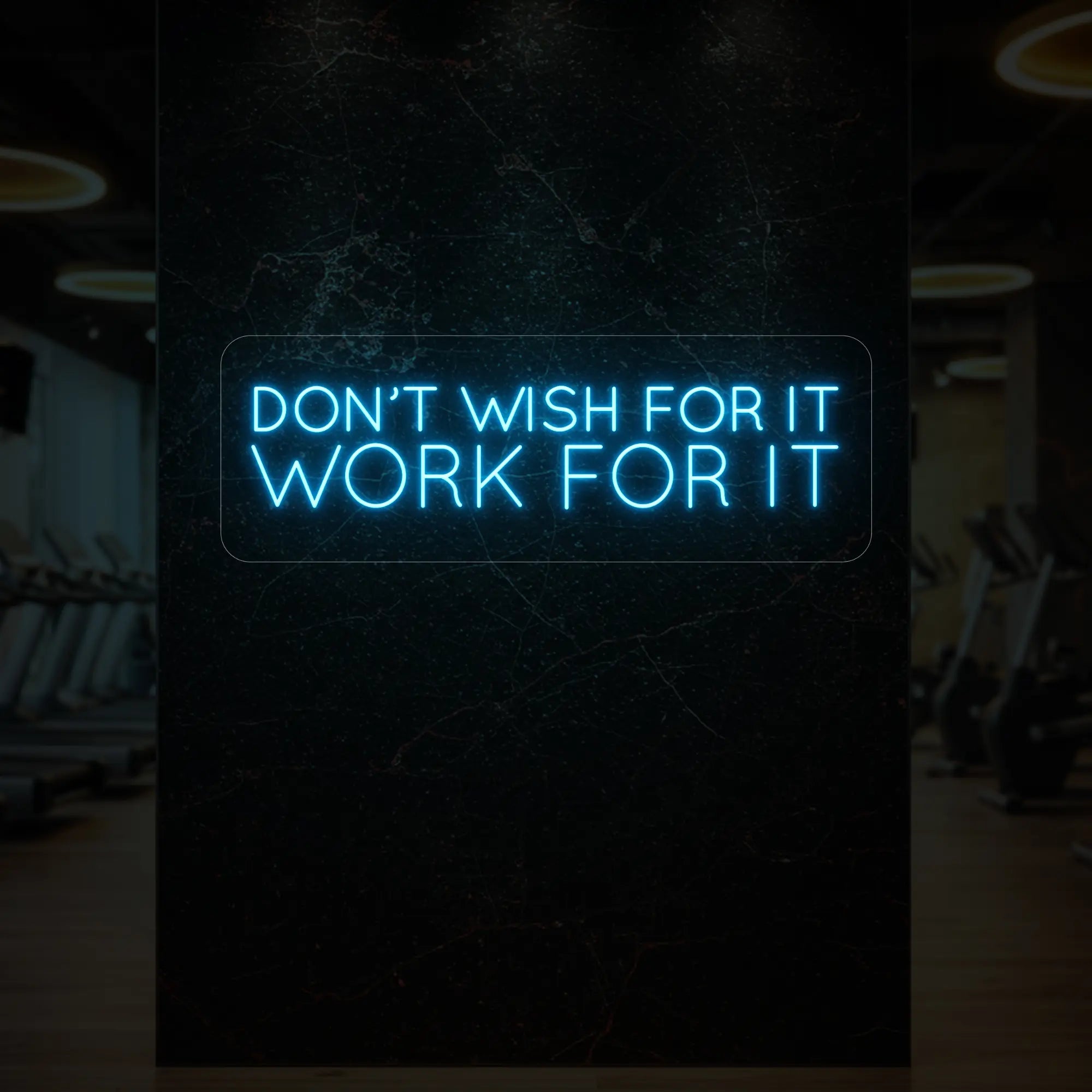 'Don’t Wish For It, Work For It' neon sign glowing in ice blue against a styled interior wall.
