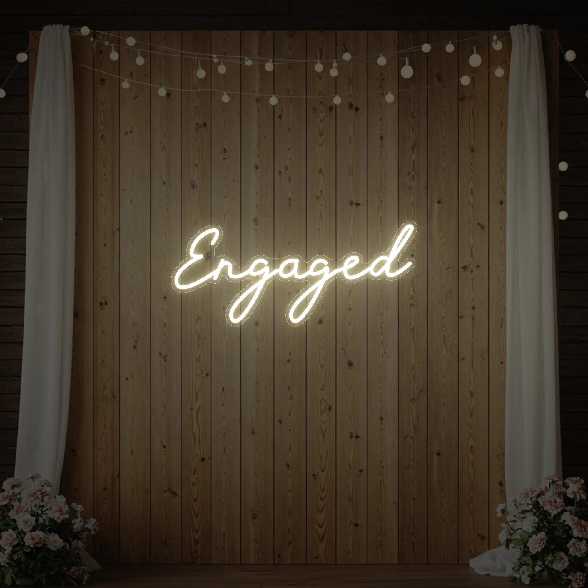 Photo of the 'Engaged' neon sign glowing in warm white against a styled interior wall.