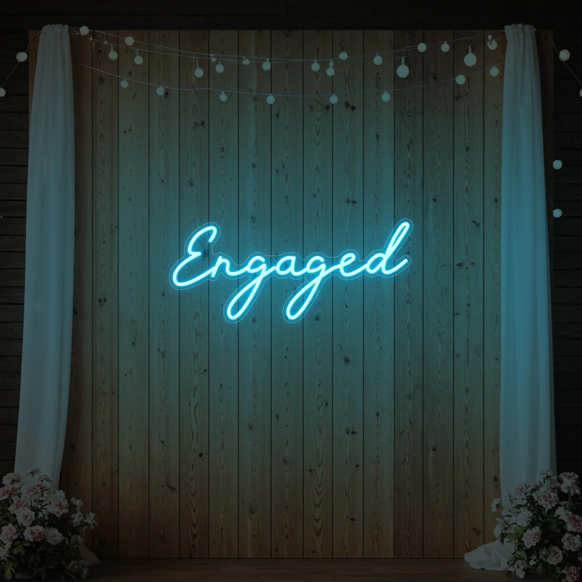 Photo of the 'Engaged' neon sign glowing in ice blue against a styled interior wall.