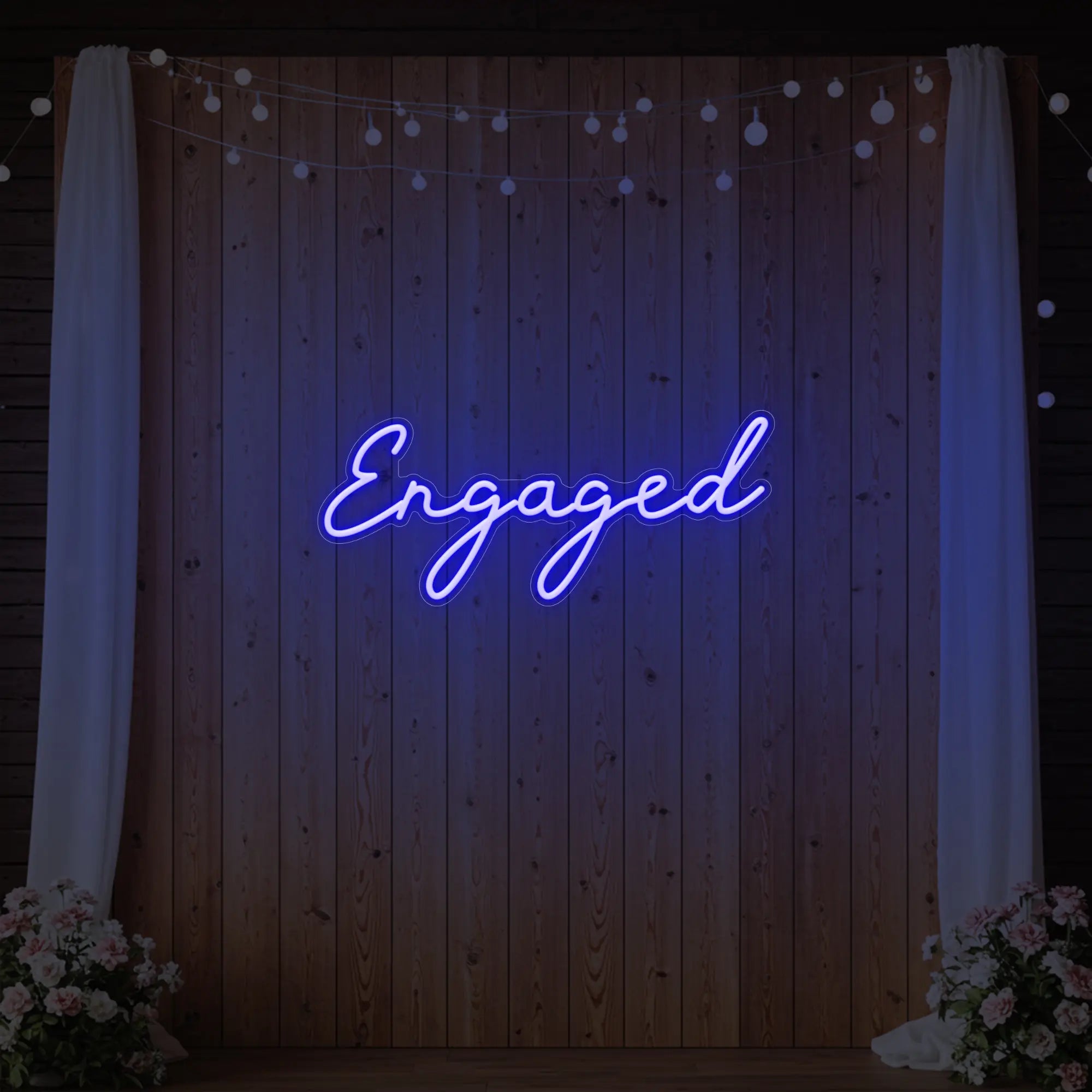Photo of the 'Engaged' neon sign glowing in deep blue against a styled interior wall.