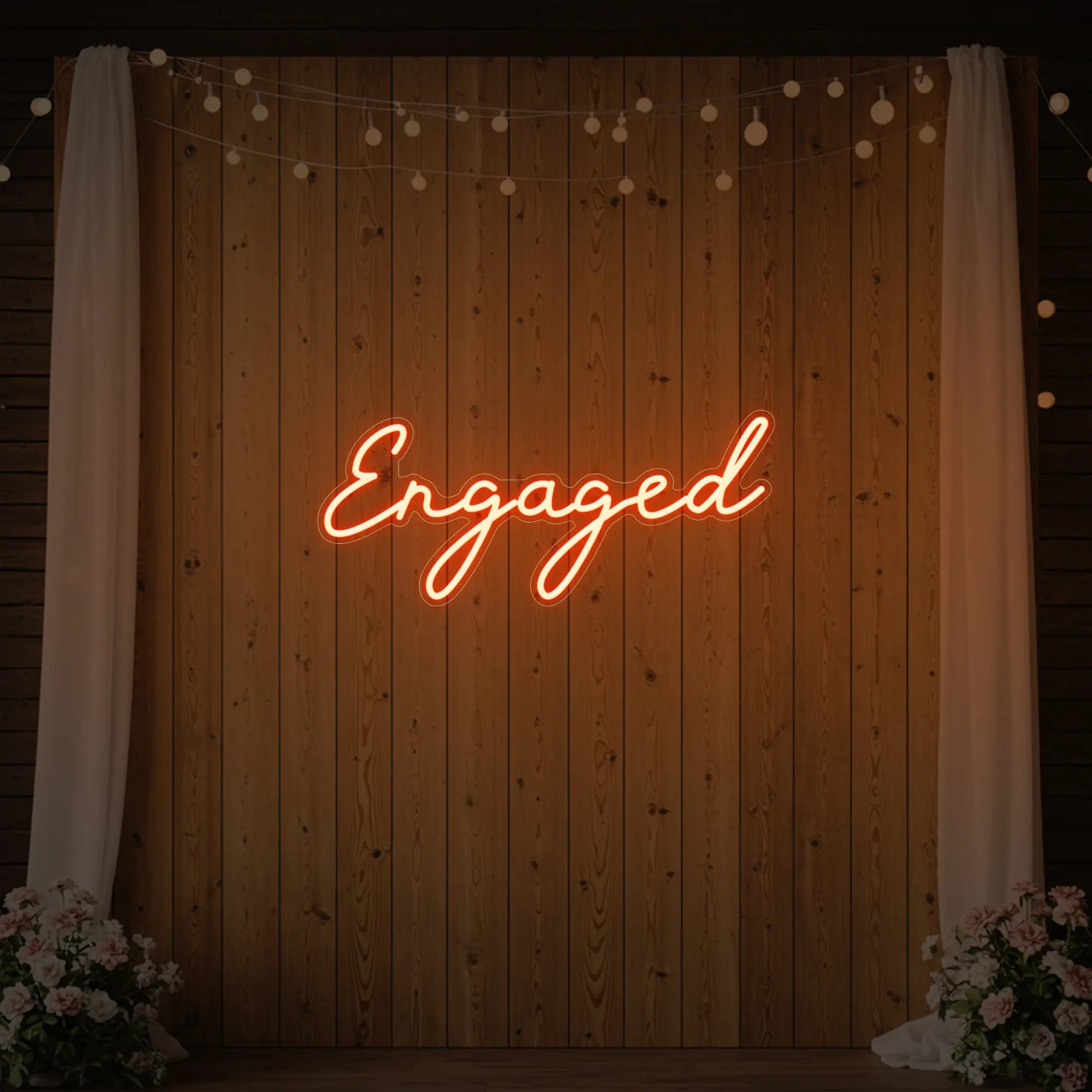 Photo of the 'Engaged' neon sign glowing in golden yellow against a styled interior wall.