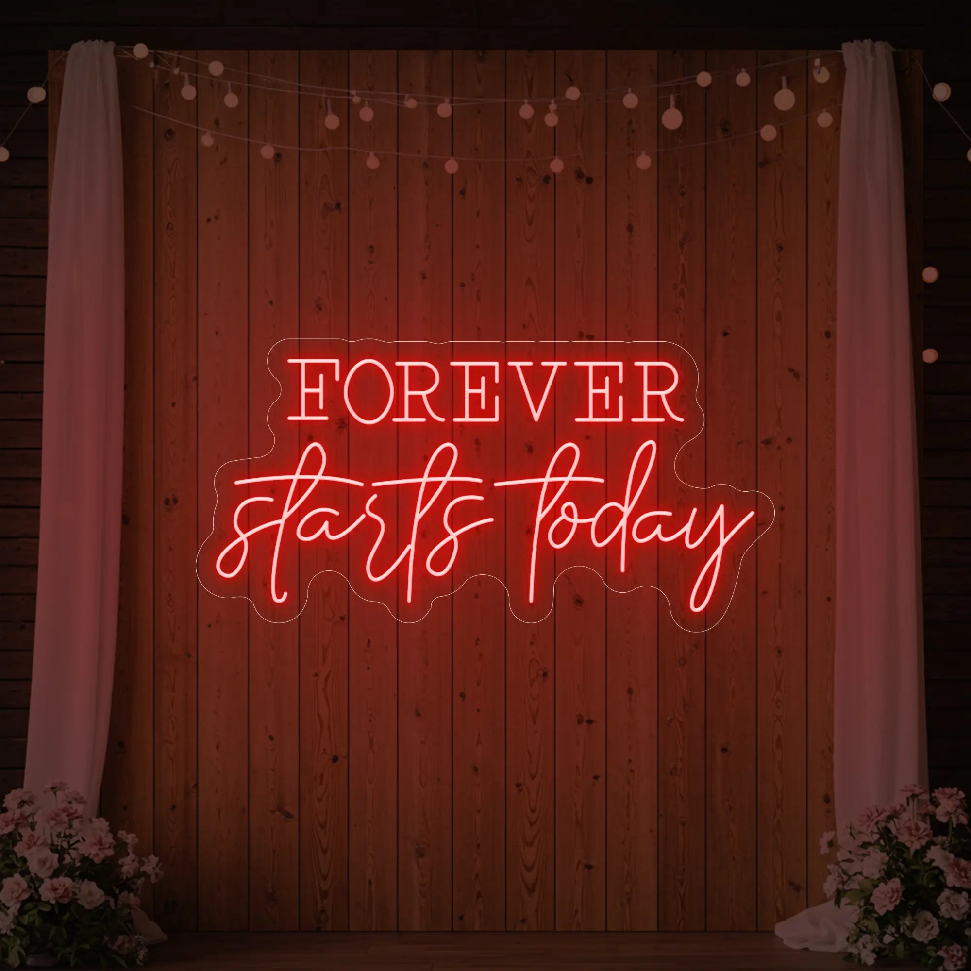 Photo of the 'Forever Starts Today' neon sign glowing in red against a styled interior wall.