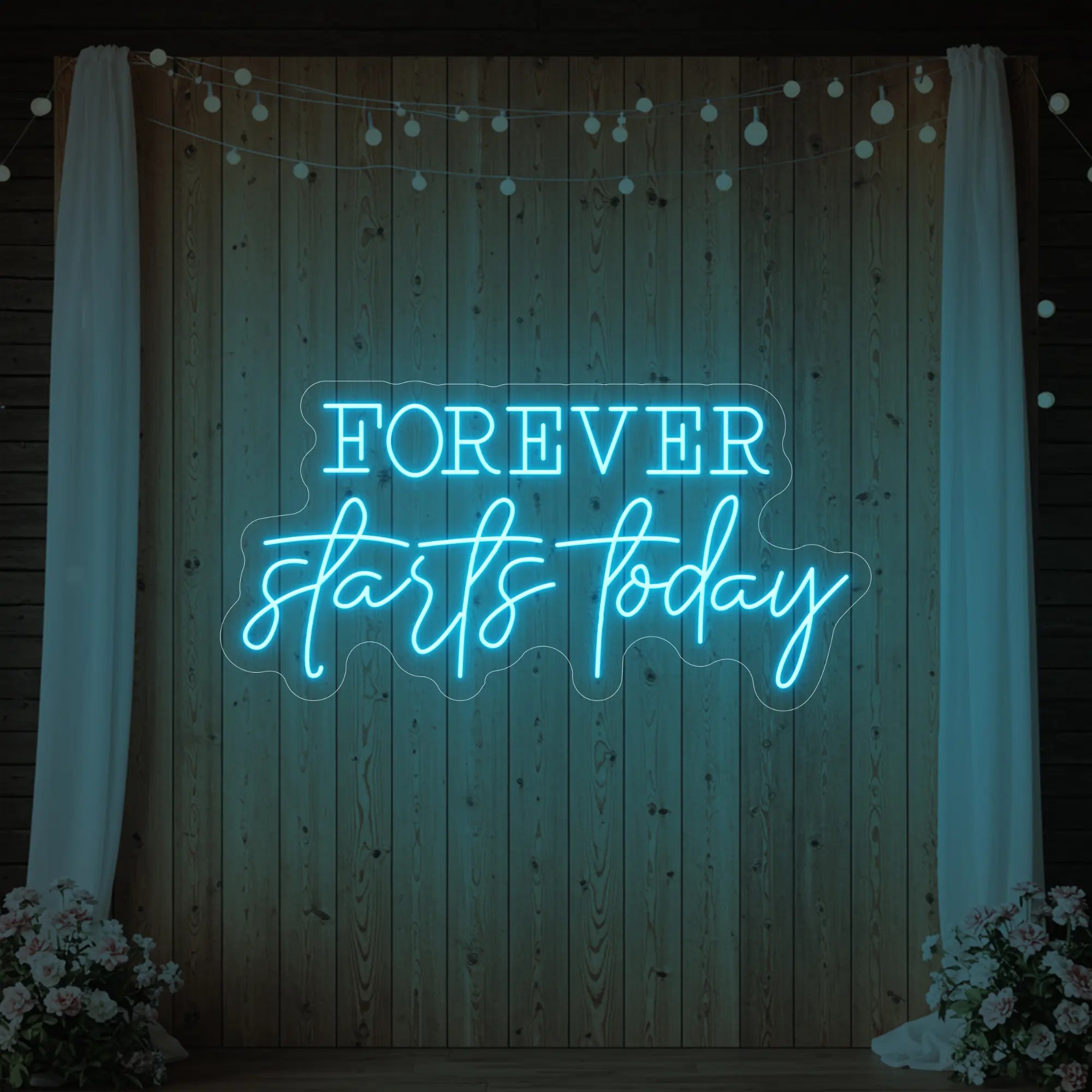 Photo of the 'Forever Starts Today' neon sign glowing in ice blue against a styled interior wall.