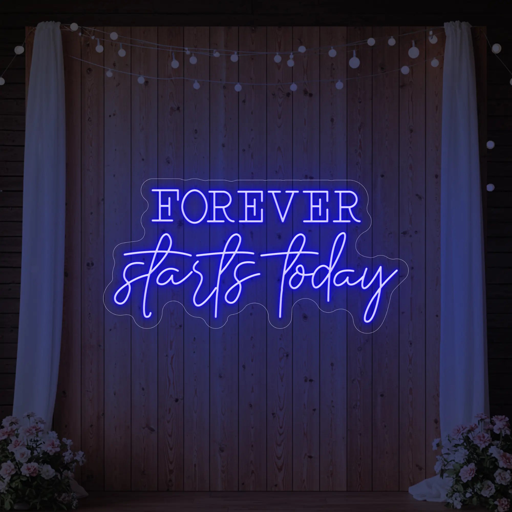 Photo of the 'Forever Starts Today' neon sign glowing in deep blue against a styled interior wall.