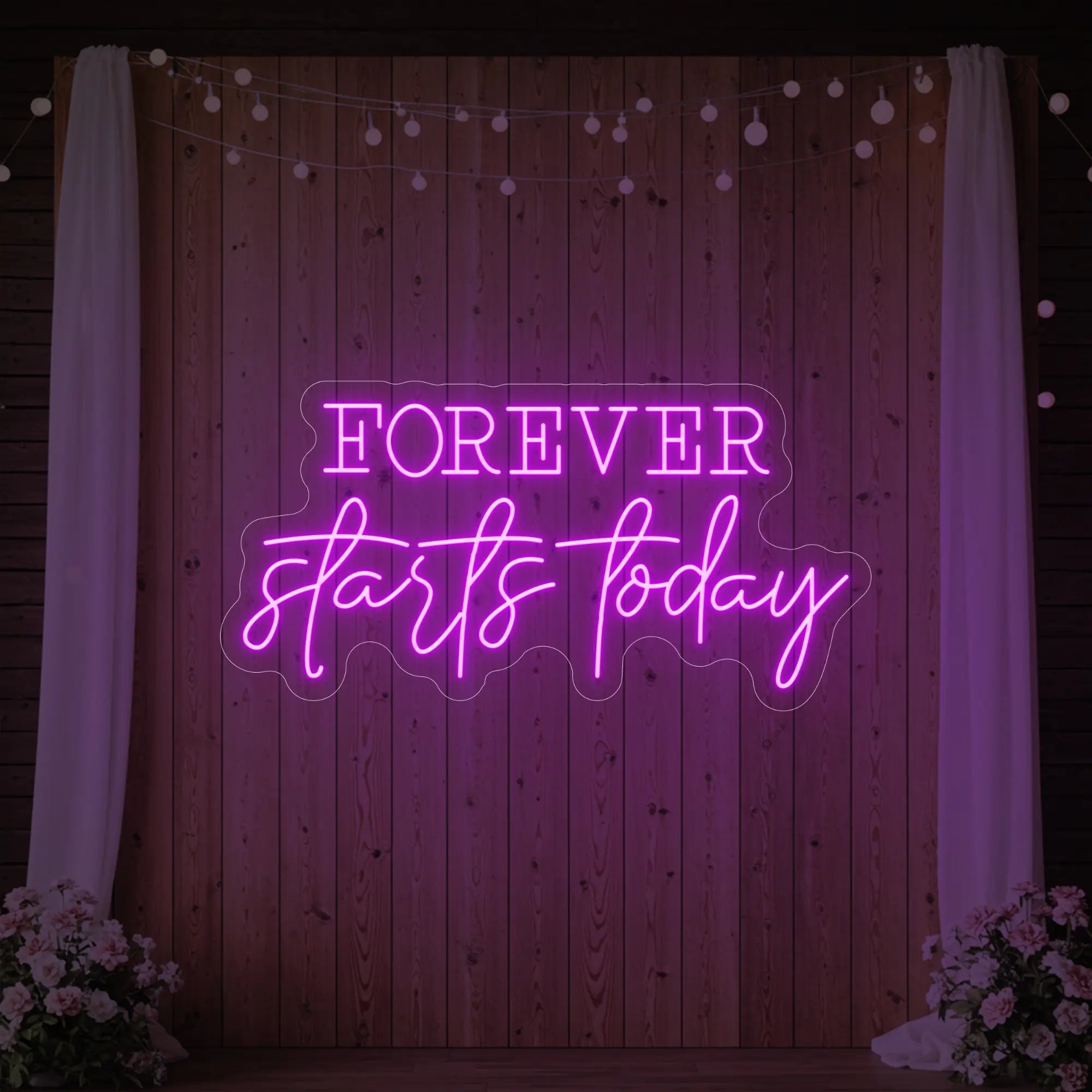 Photo of the 'Forever Starts Today' neon sign glowing in deep pink against a styled interior wall.