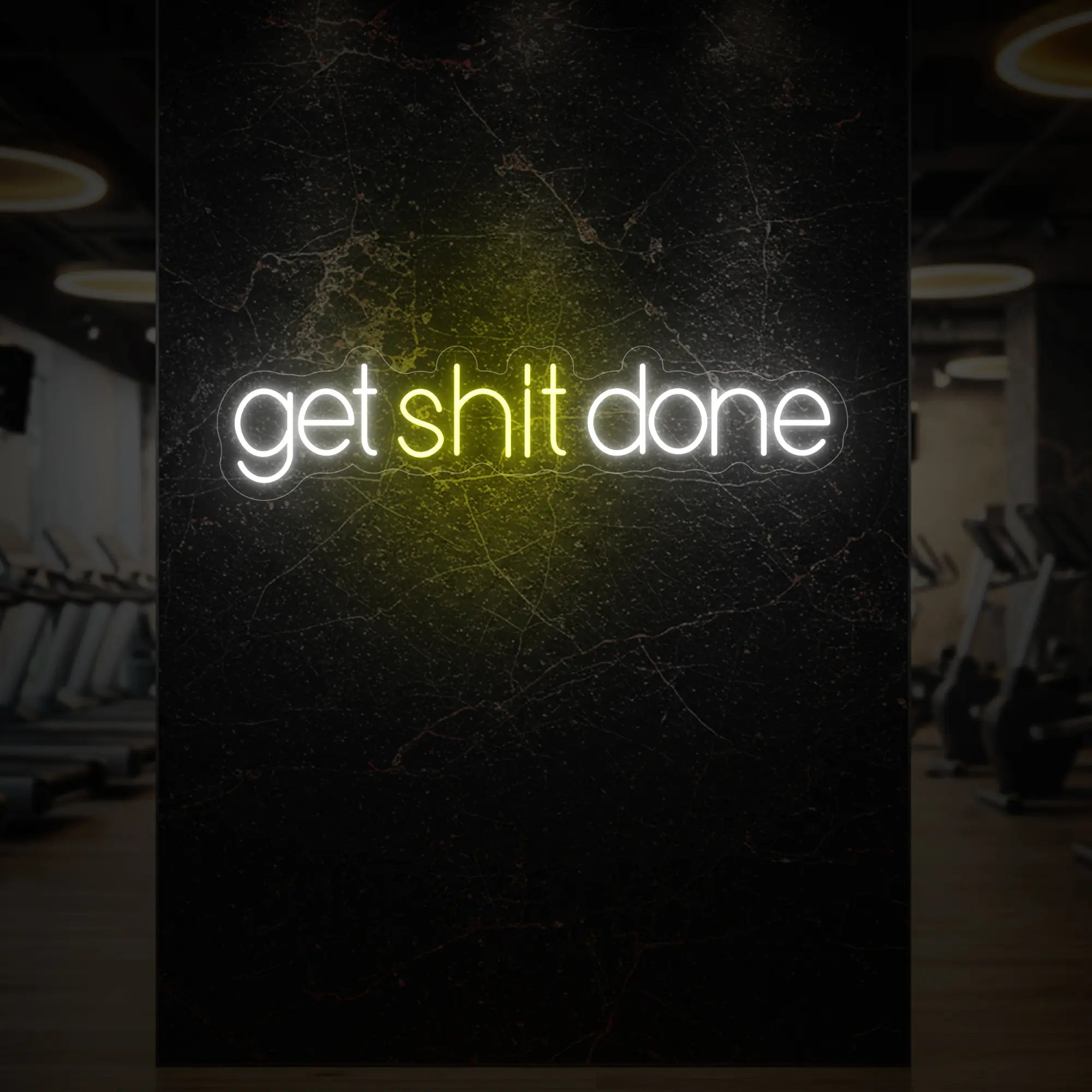 'Get Shit Done' neon sign glowing in lemon yellow against a styled interior wall.