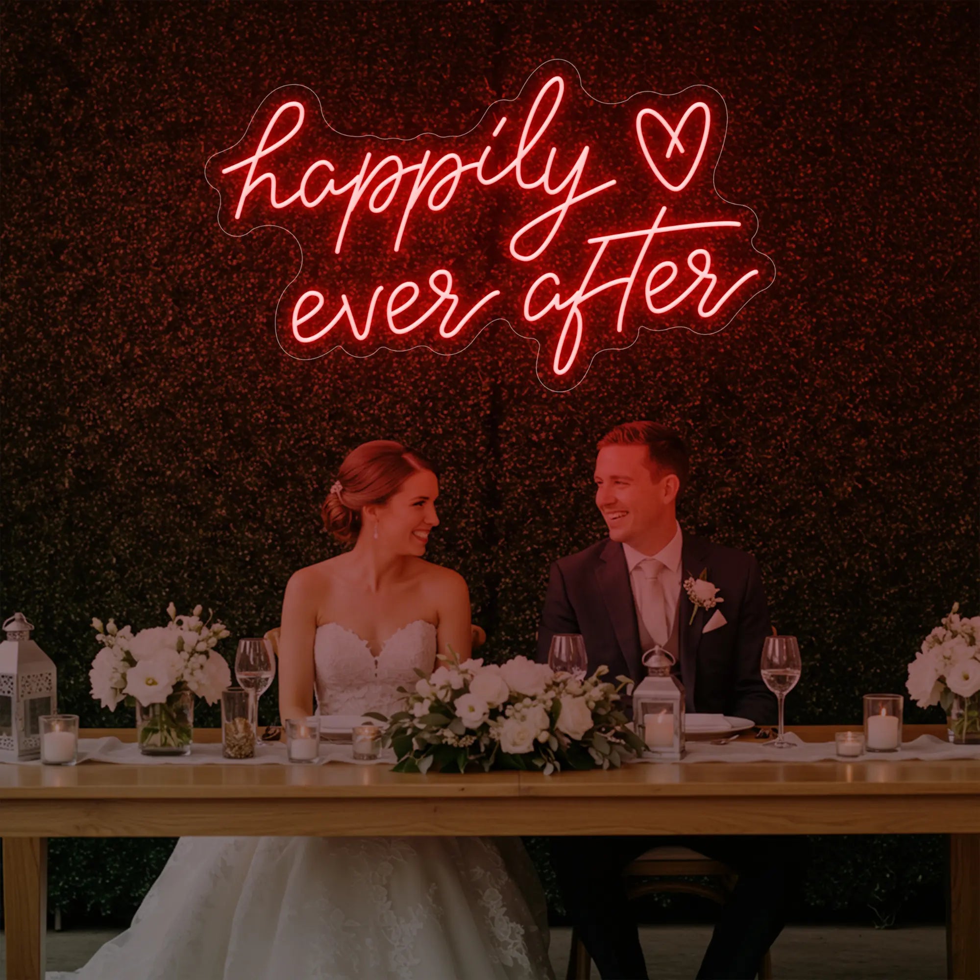 Photo of the 'Happily Ever After' neon sign glowing in red against a styled interior wall.