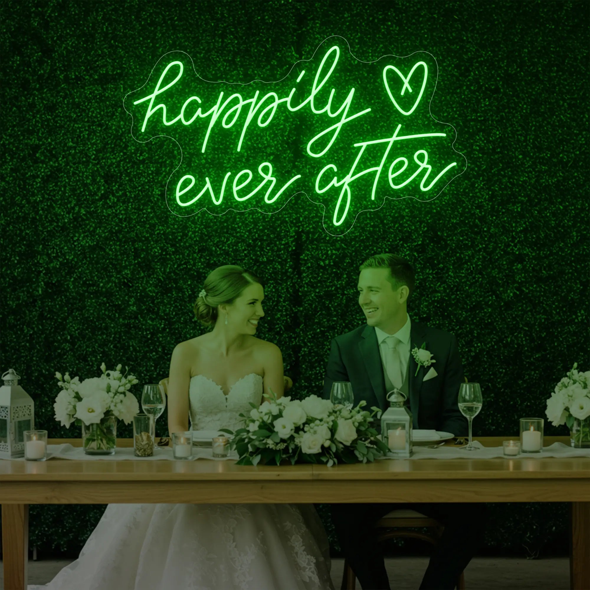 Photo of the 'Happily Ever After' neon sign glowing in green against a styled interior wall.