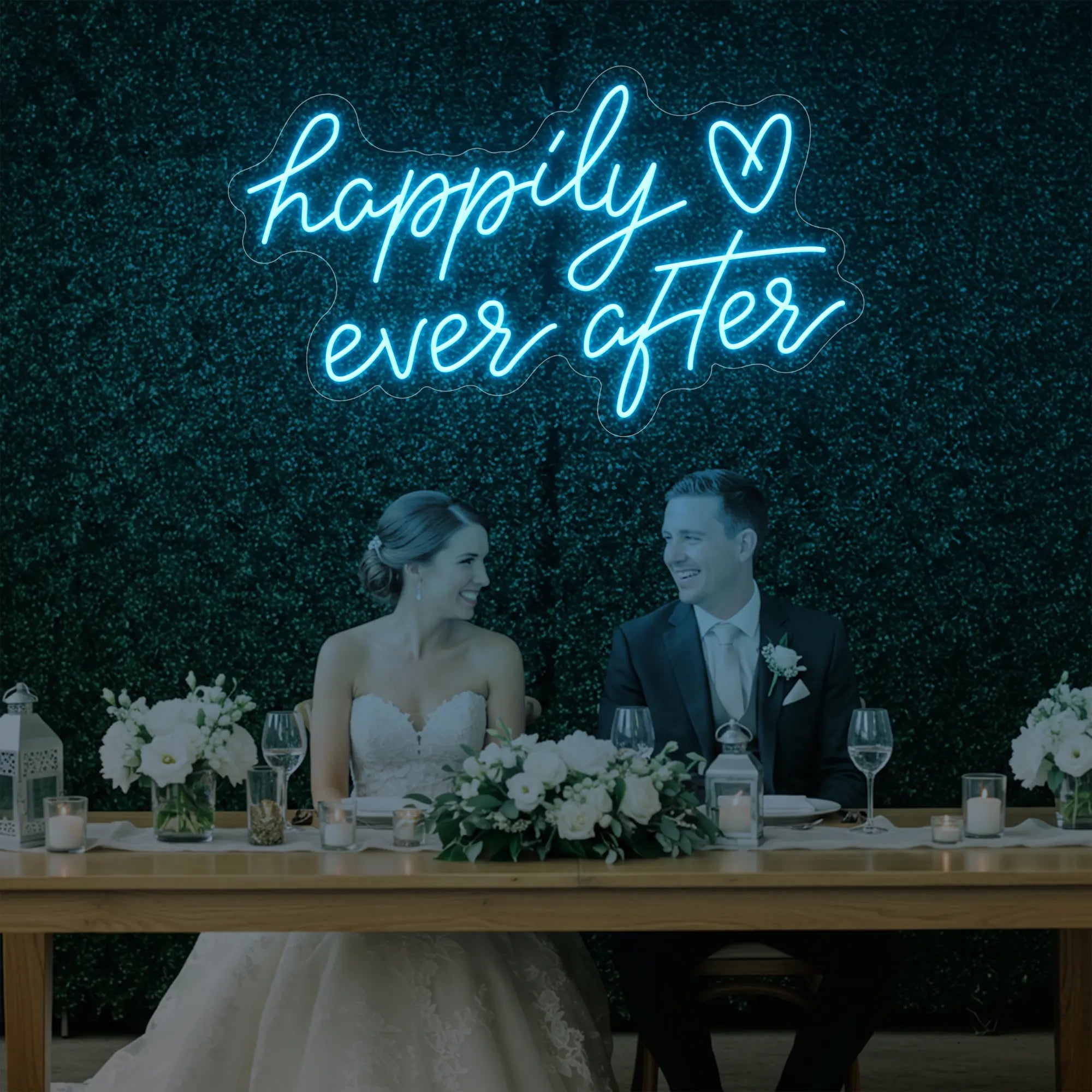 Photo of the 'Happily Ever After' neon sign glowing in ice blue against a styled interior wall.