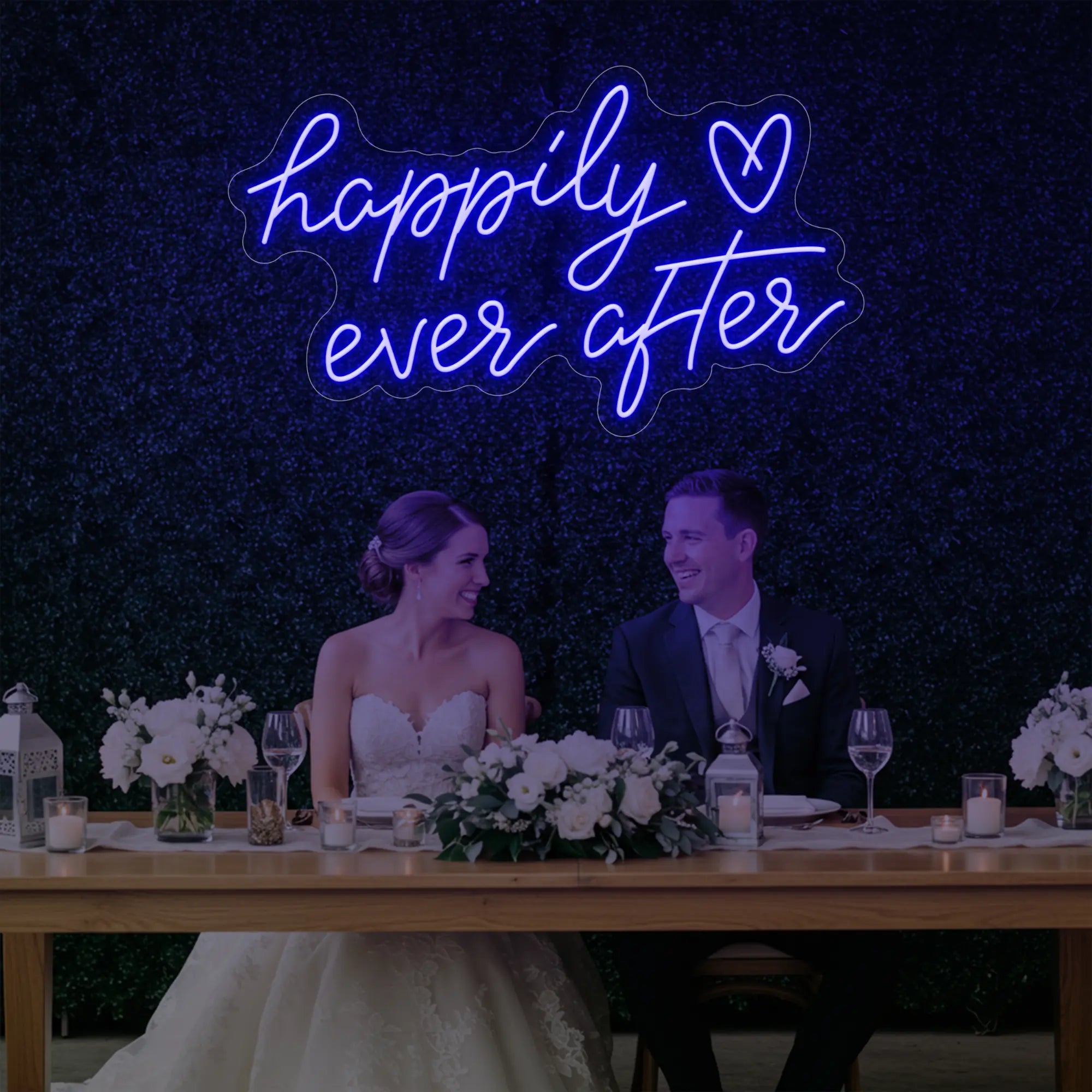 Photo of the 'Happily Ever After' neon sign glowing in deep blue against a styled interior wall.