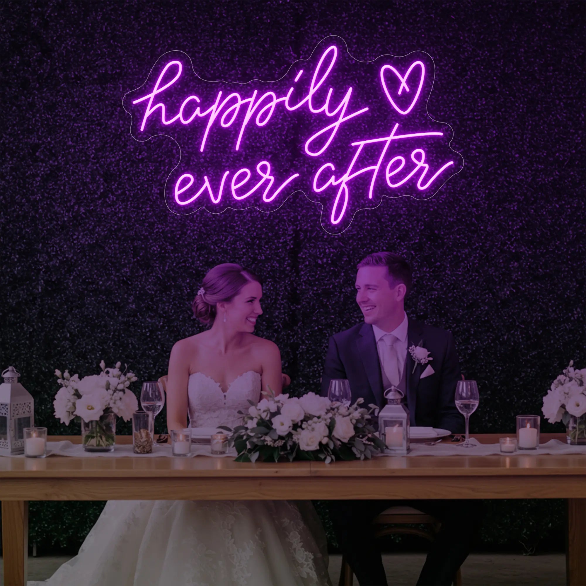 Photo of the 'Happily Ever After' neon sign glowing in deep pink against a styled interior wall.