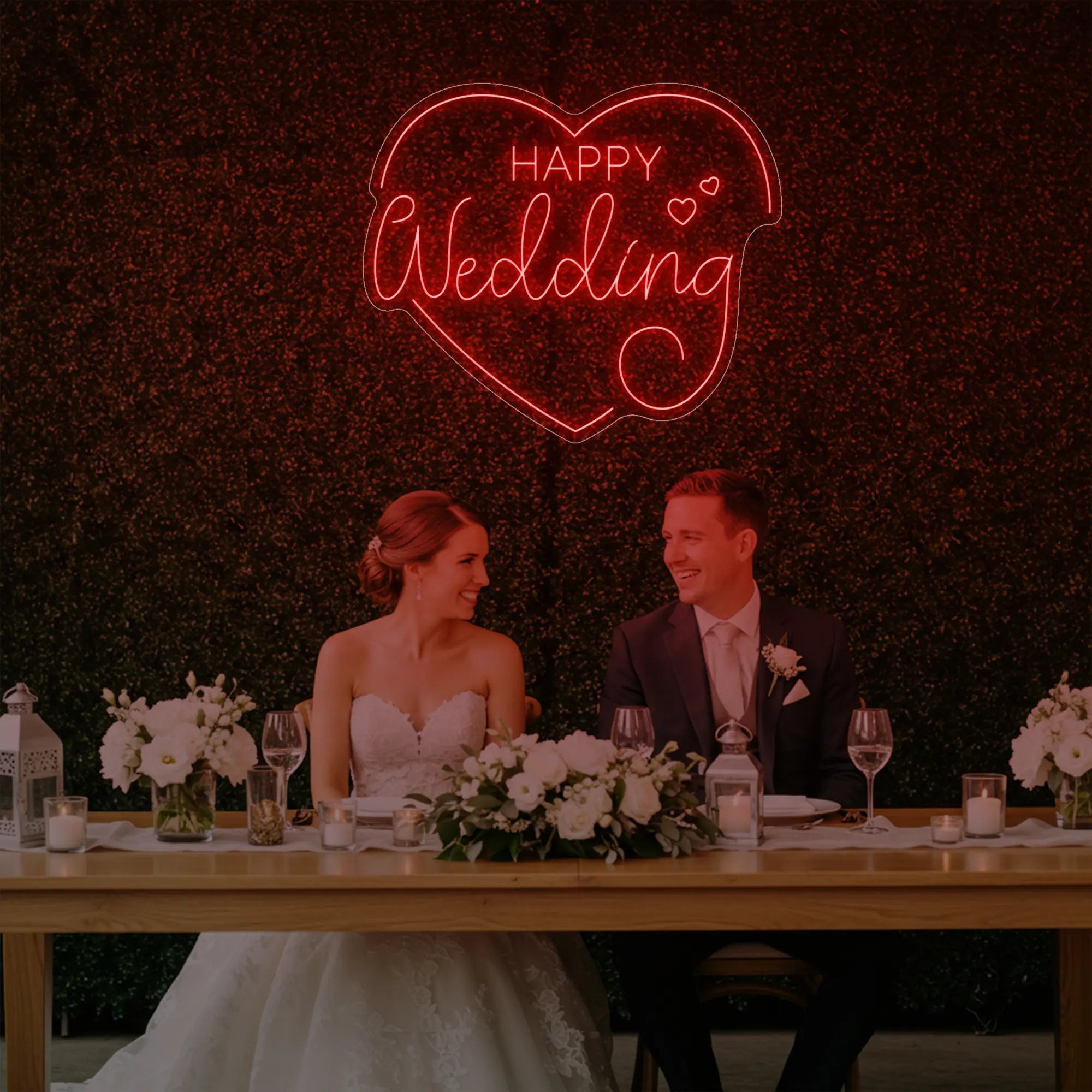 Photo of the 'Happy Wedding' neon sign glowing in red against a styled interior wall.