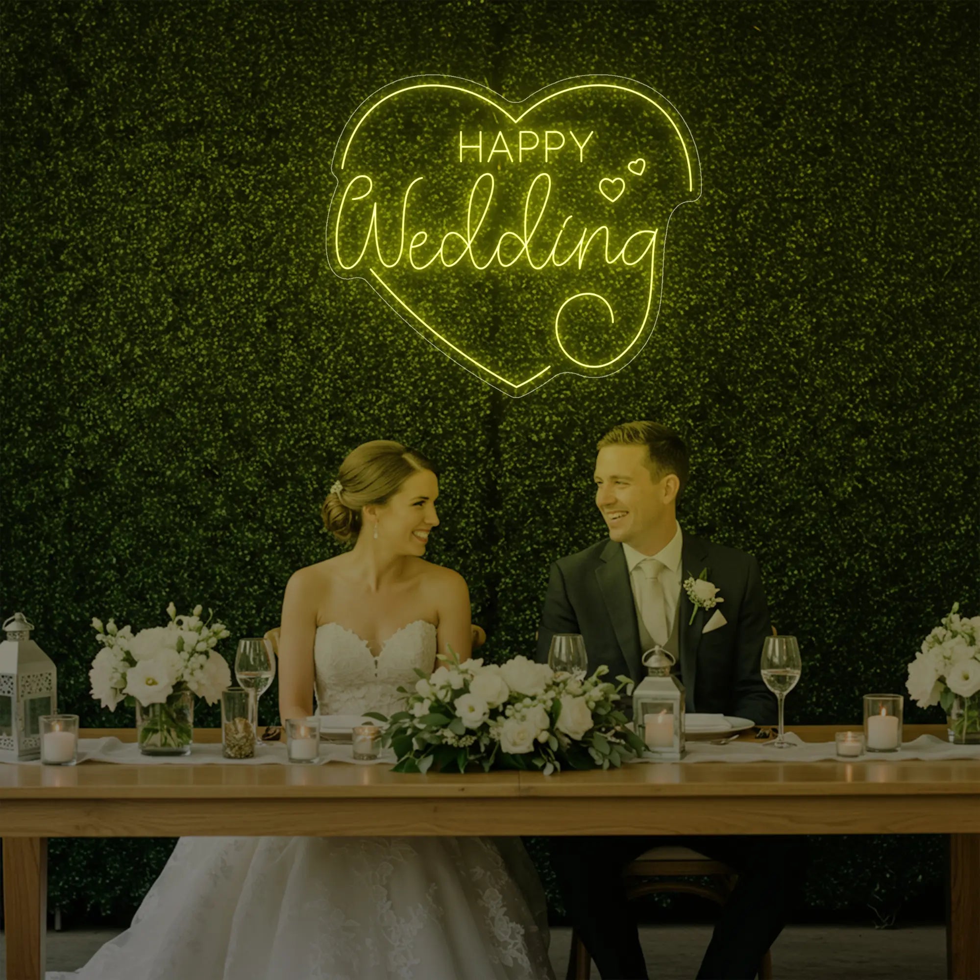 Photo of the 'Happy Wedding' neon sign glowing in lemon yellow against a styled interior wall.