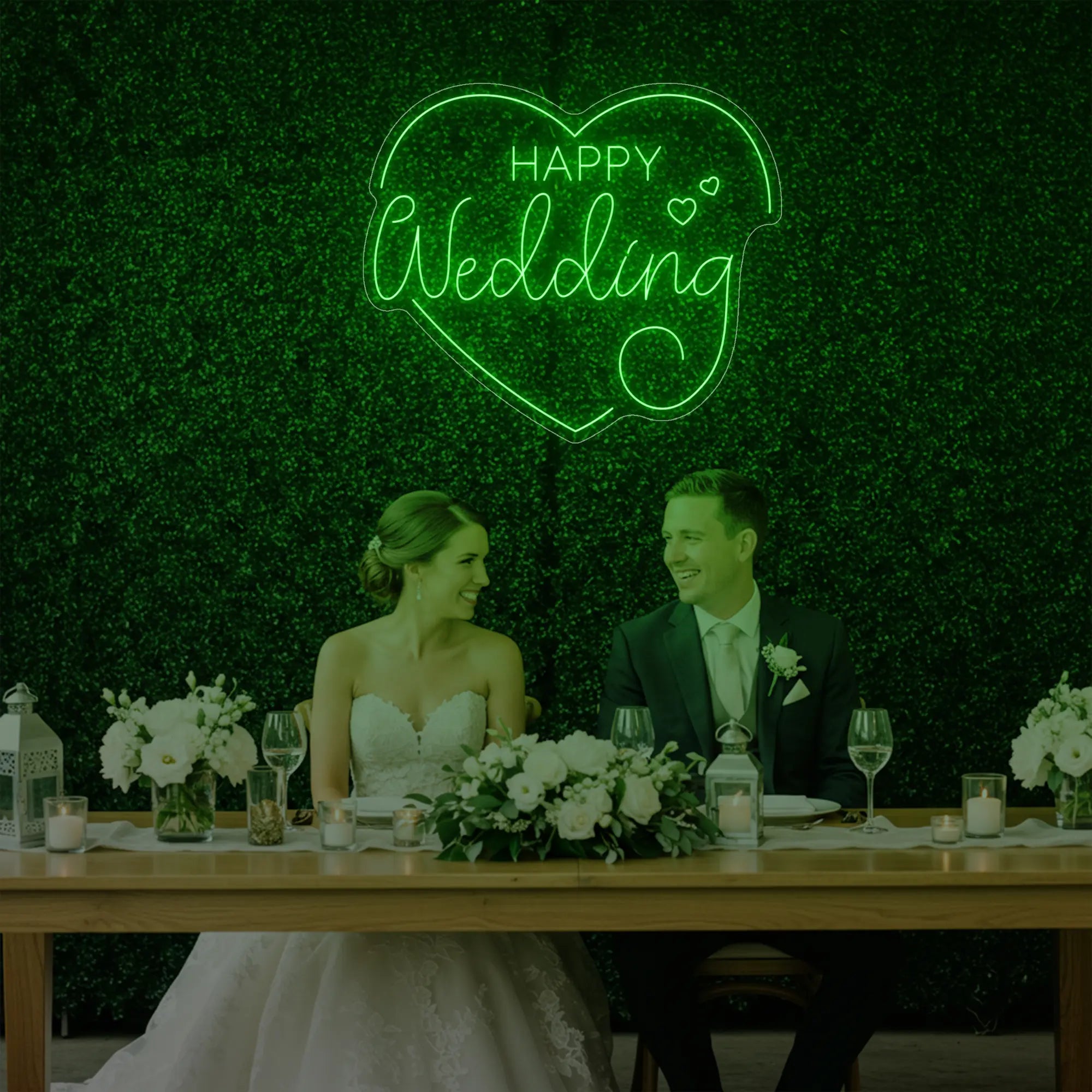 Photo of the 'Happy Wedding' neon sign glowing in green against a styled interior wall.