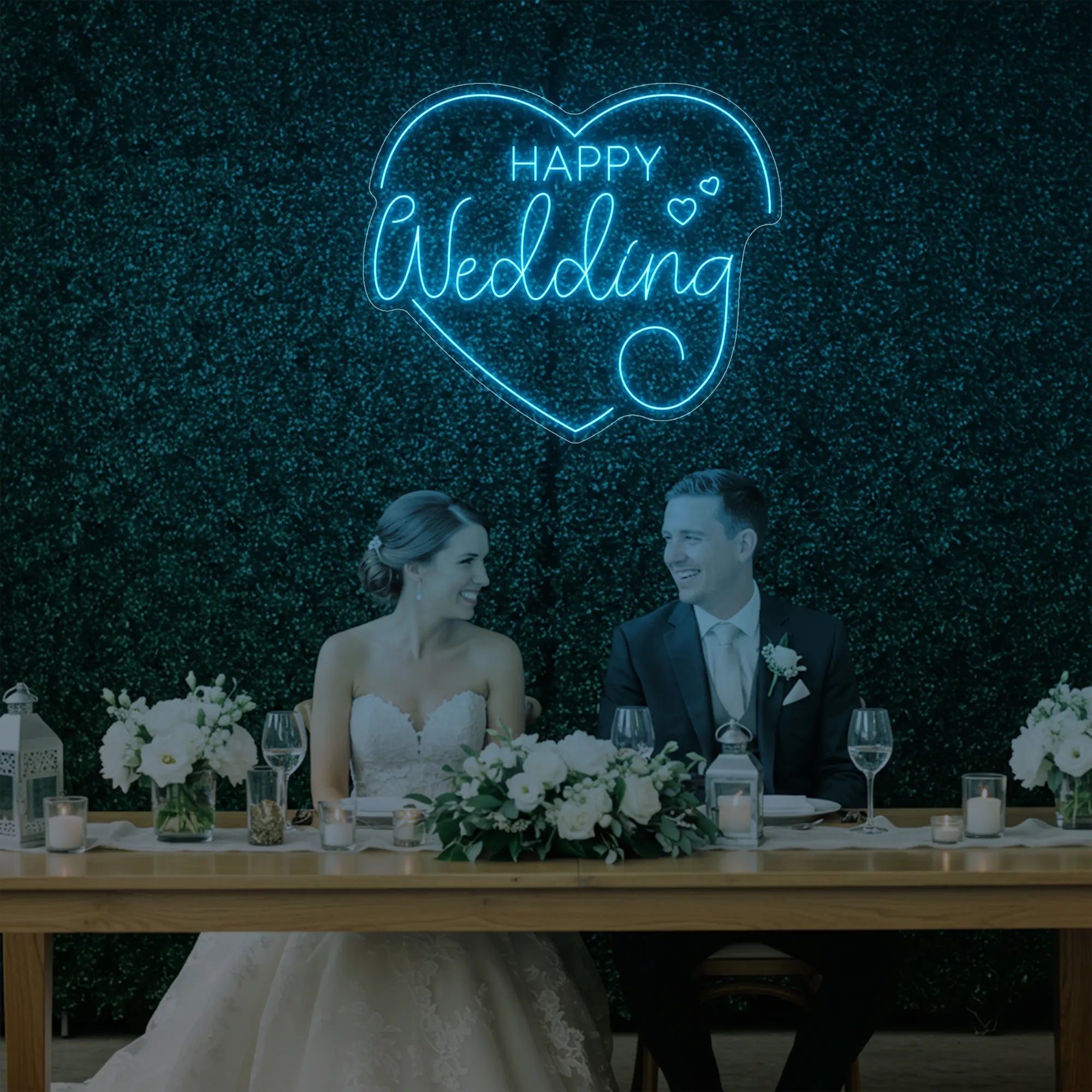 Photo of the 'Happy Wedding' neon sign glowing in ice blue against a styled interior wall.
