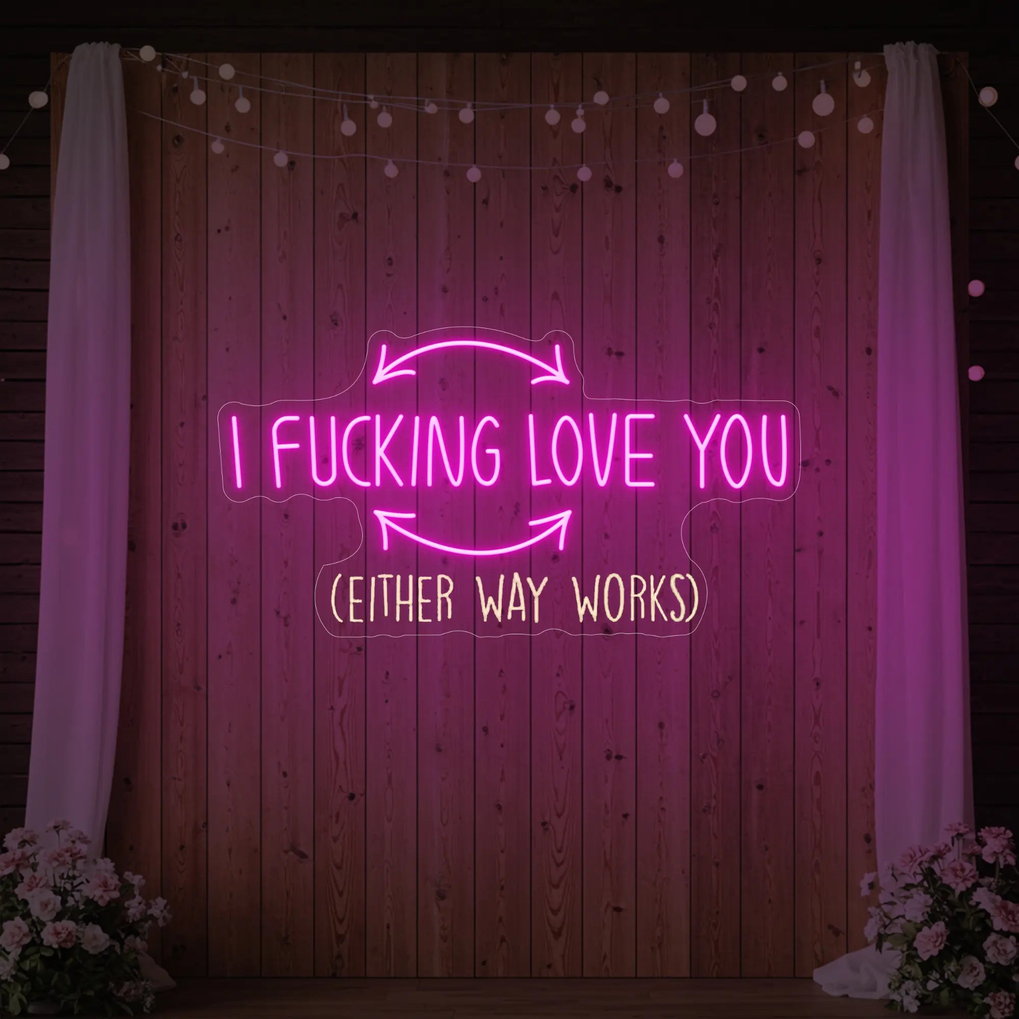 Photo of the 'I F'ing Love You' neon sign glowing in light pink against a styled interior wall.