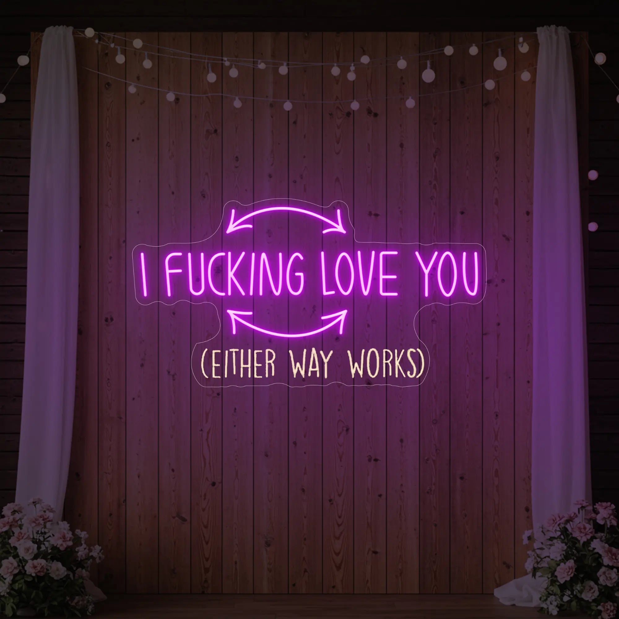 Photo of the 'I F'ing Love You' neon sign glowing in deep pink against a styled interior wall.