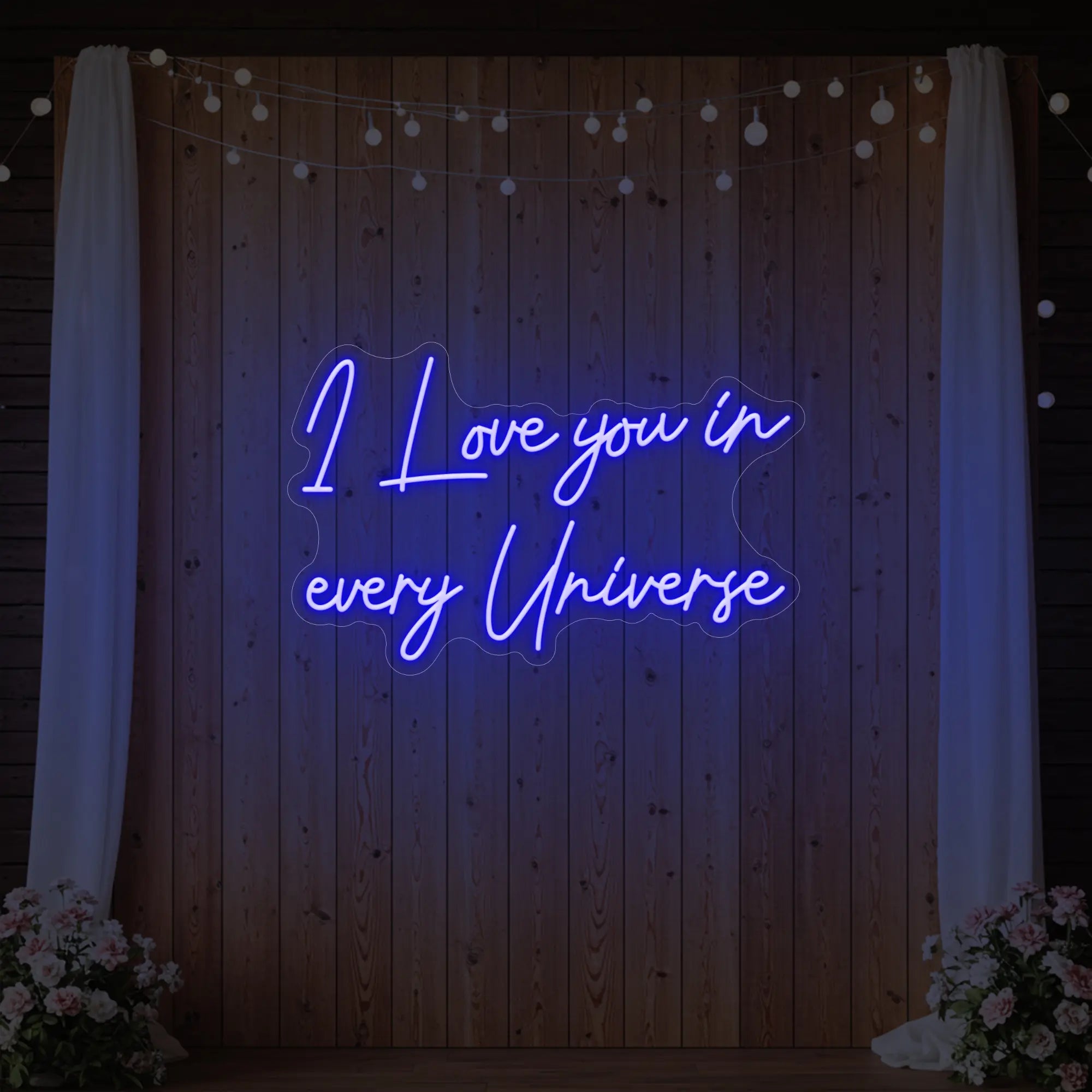 Photo of the 'I Love You In Every Universe' neon sign glowing in deep blue against a styled interior wall.