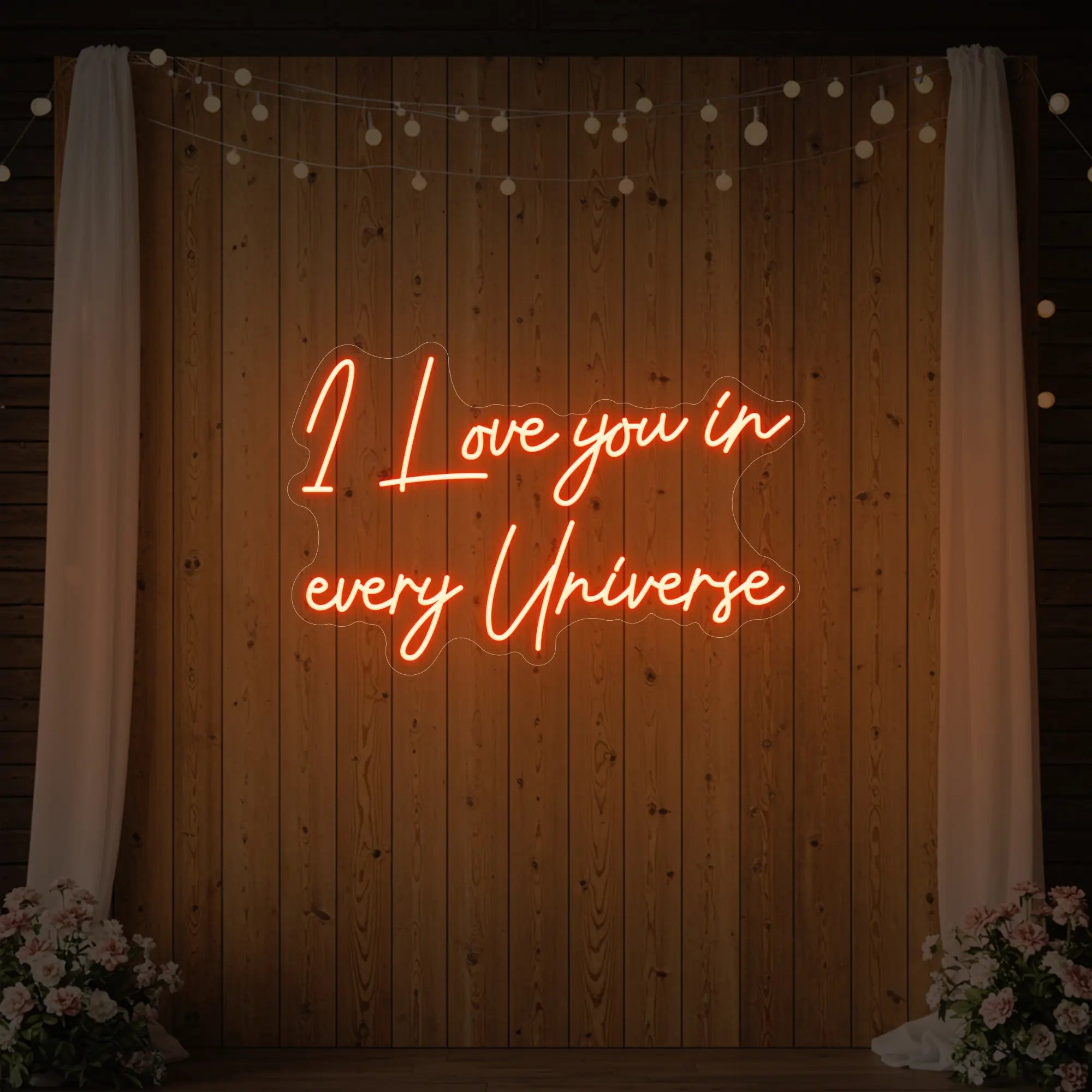 Photo of the 'I Love You In Every Universe' neon sign glowing in golden yellow against a styled interior wall.