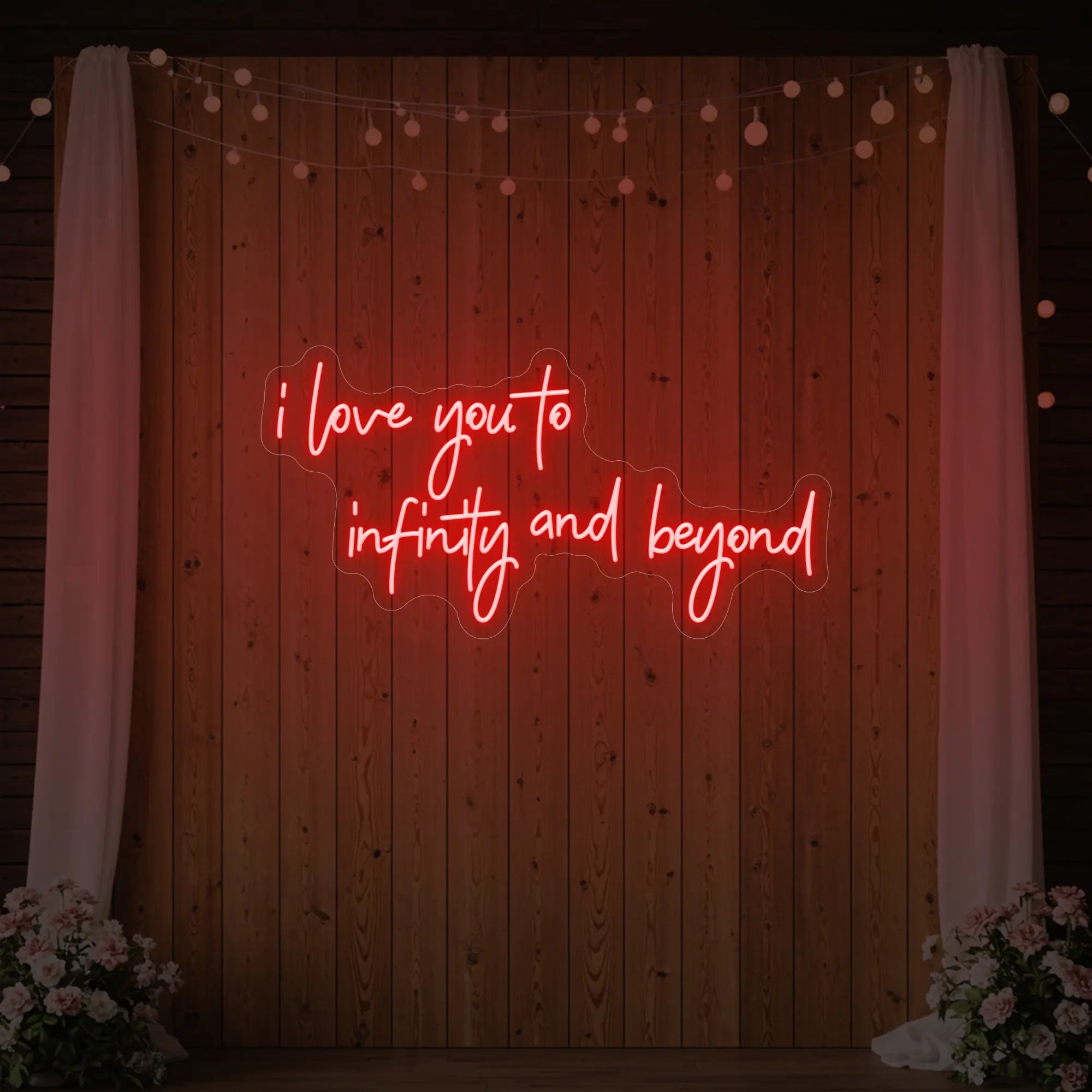 Photo of the 'I Love You to Infinity and Beyond' neon sign glowing in red against a styled interior wall.