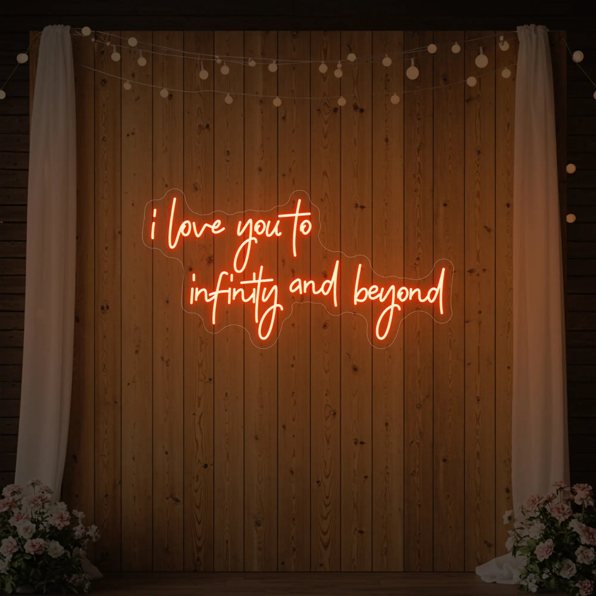 Photo of the 'I Love You to Infinity and Beyond' neon sign glowing in golden yellow against a styled interior wall.