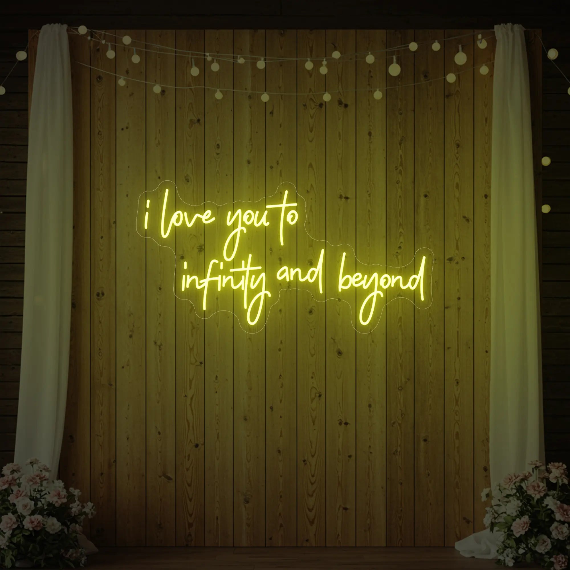 Photo of the 'I Love You to Infinity and Beyond' neon sign glowing in lemon yellow against a styled interior wall.