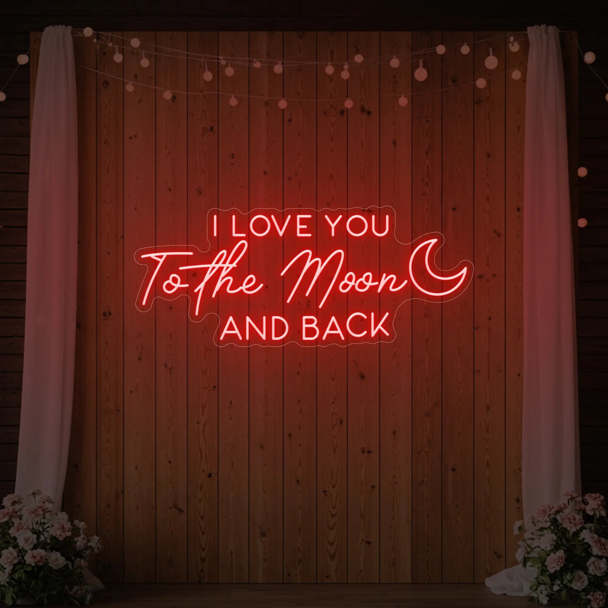 Photo of the 'I Love You To The Moon And Back' neon sign glowing in red against a styled interior wall.