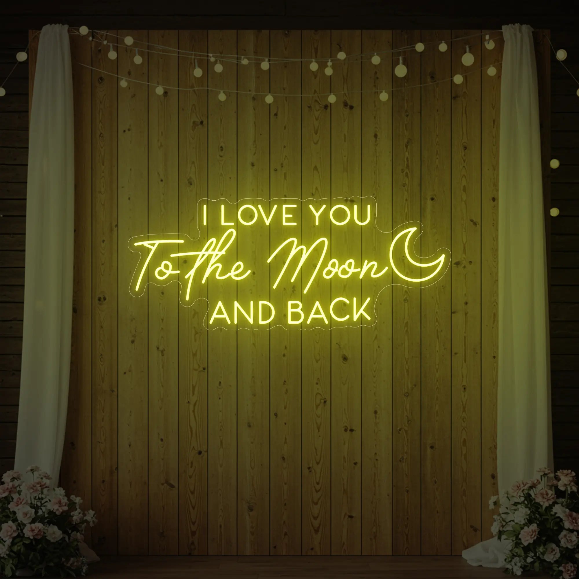 Photo of the 'I Love You To The Moon And Back' neon sign glowing in lemon yellow against a styled interior wall.