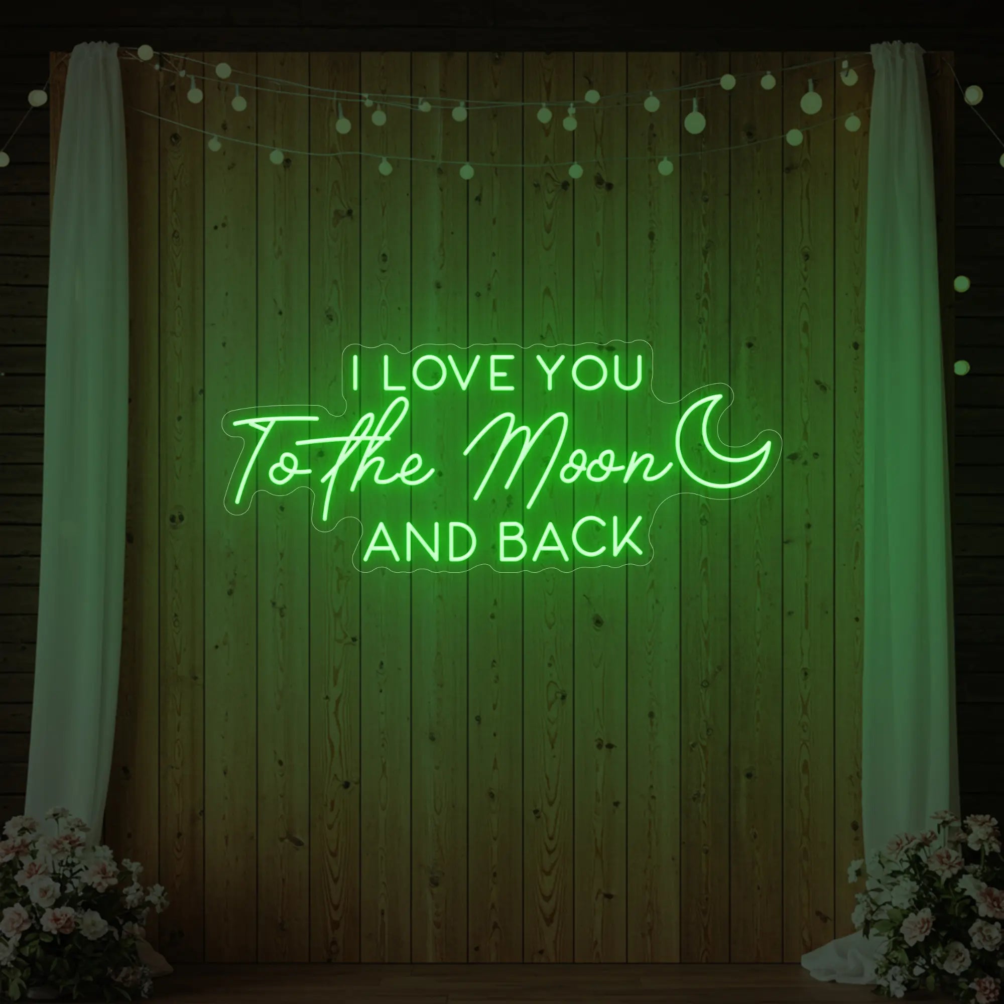 Photo of the 'I Love You To The Moon And Back' neon sign glowing in green against a styled interior wall.