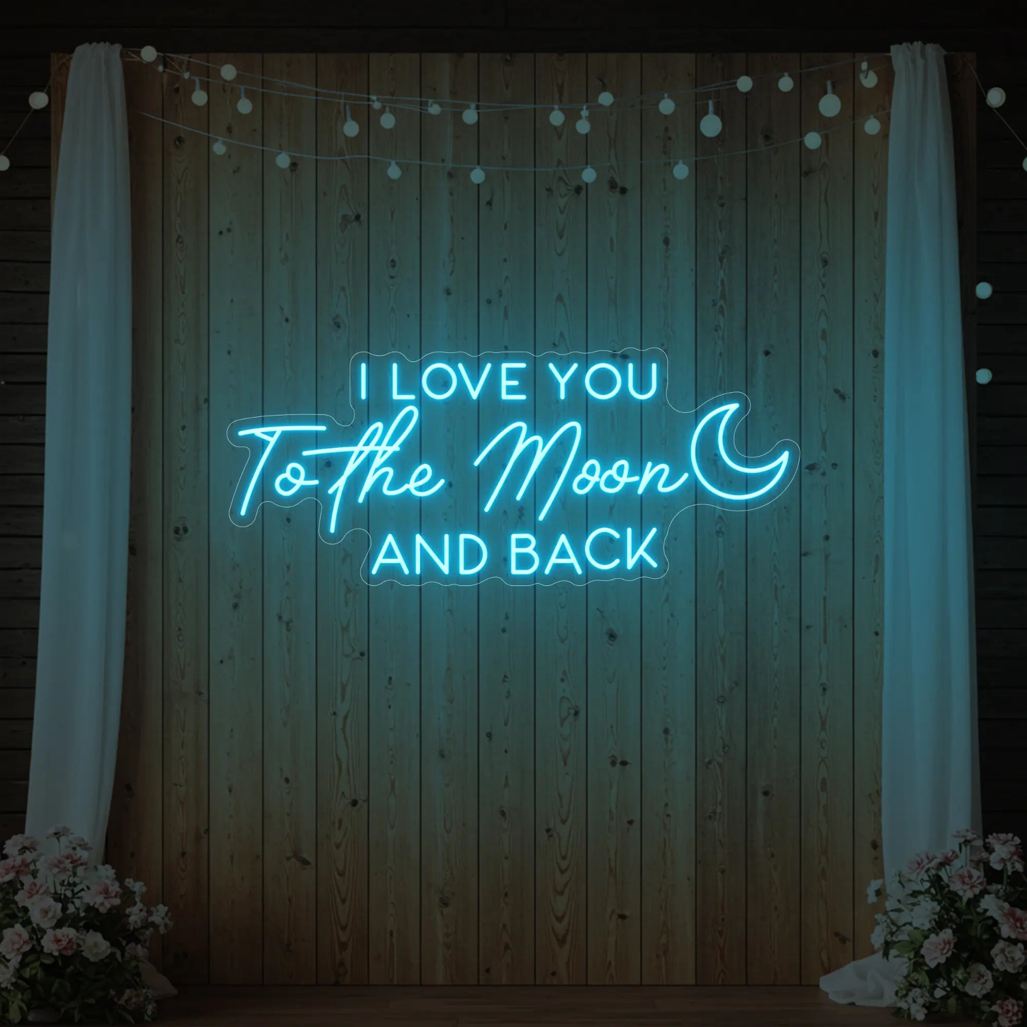 Photo of the 'I Love You To The Moon And Back' neon sign glowing in ice blue against a styled interior wall.