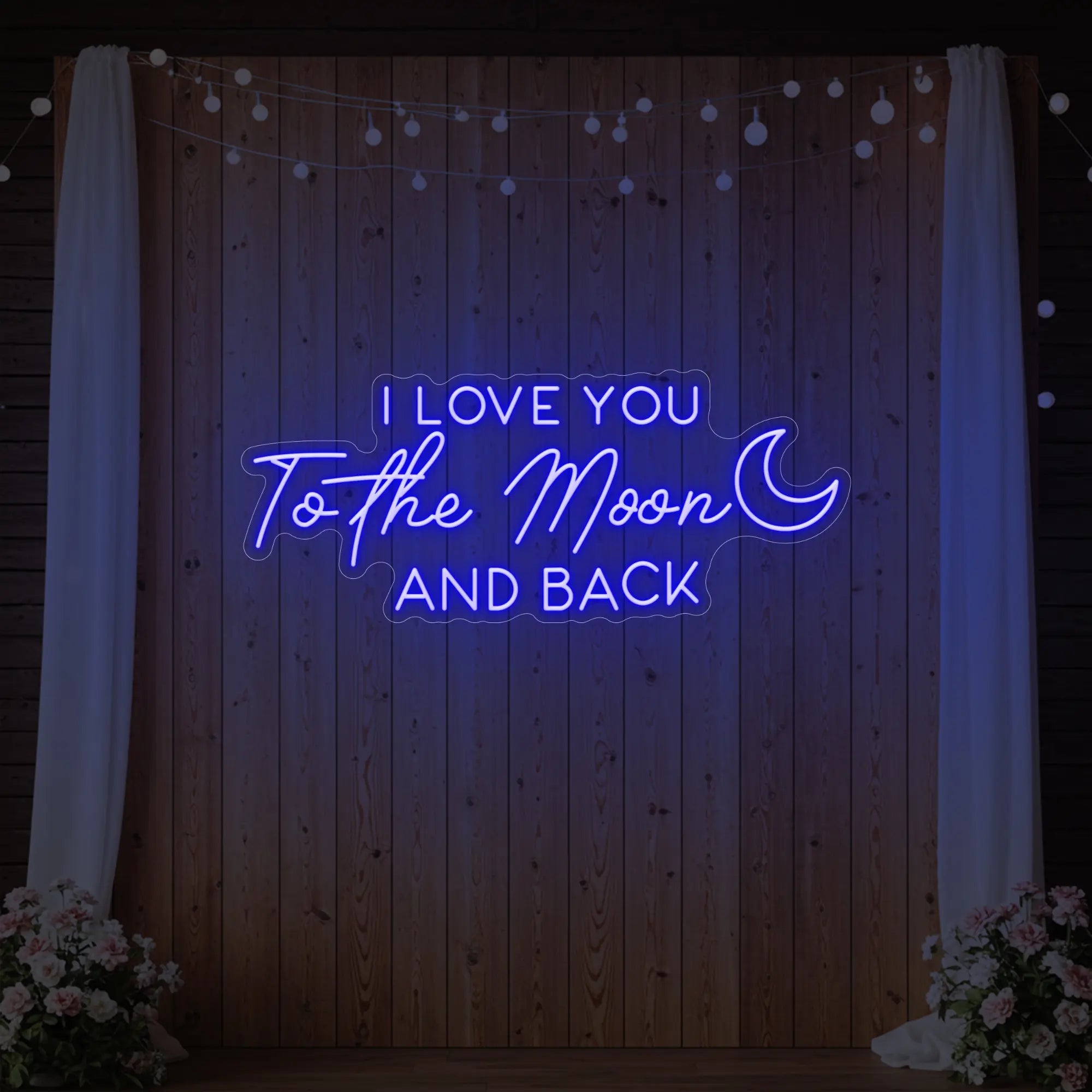 Photo of the 'I Love You To The Moon And Back' neon sign glowing in deep blue against a styled interior wall.