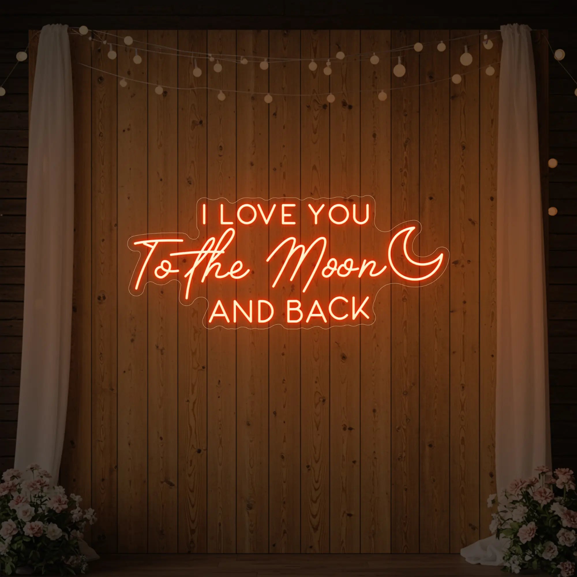 Photo of the 'I Love You To The Moon And Back' neon sign glowing in golden yellow against a styled interior wall.
