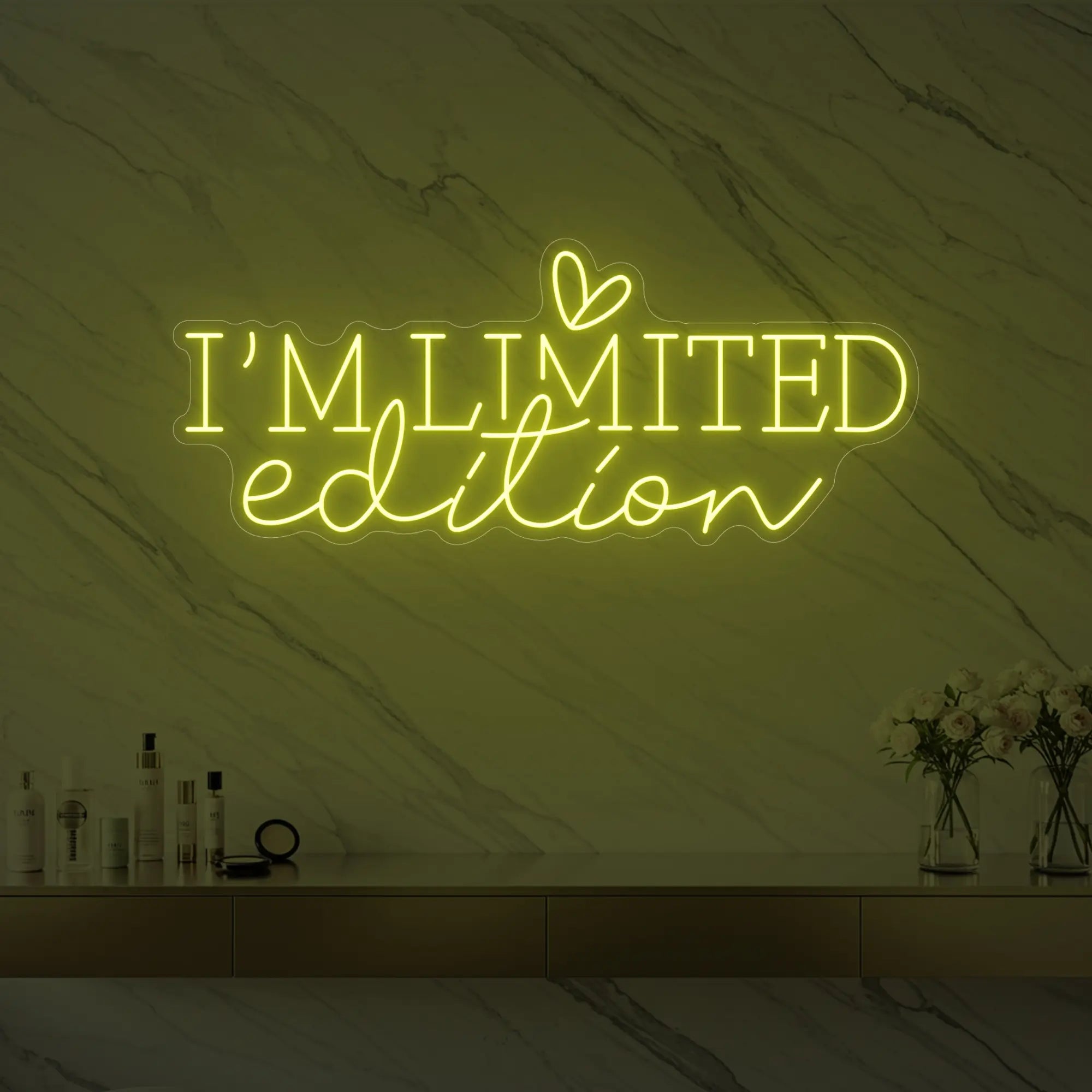 Photo of the 'I’M LIMITED edition' neon sign with a heart icon glowing in lemon yellow against a styled interior wall.