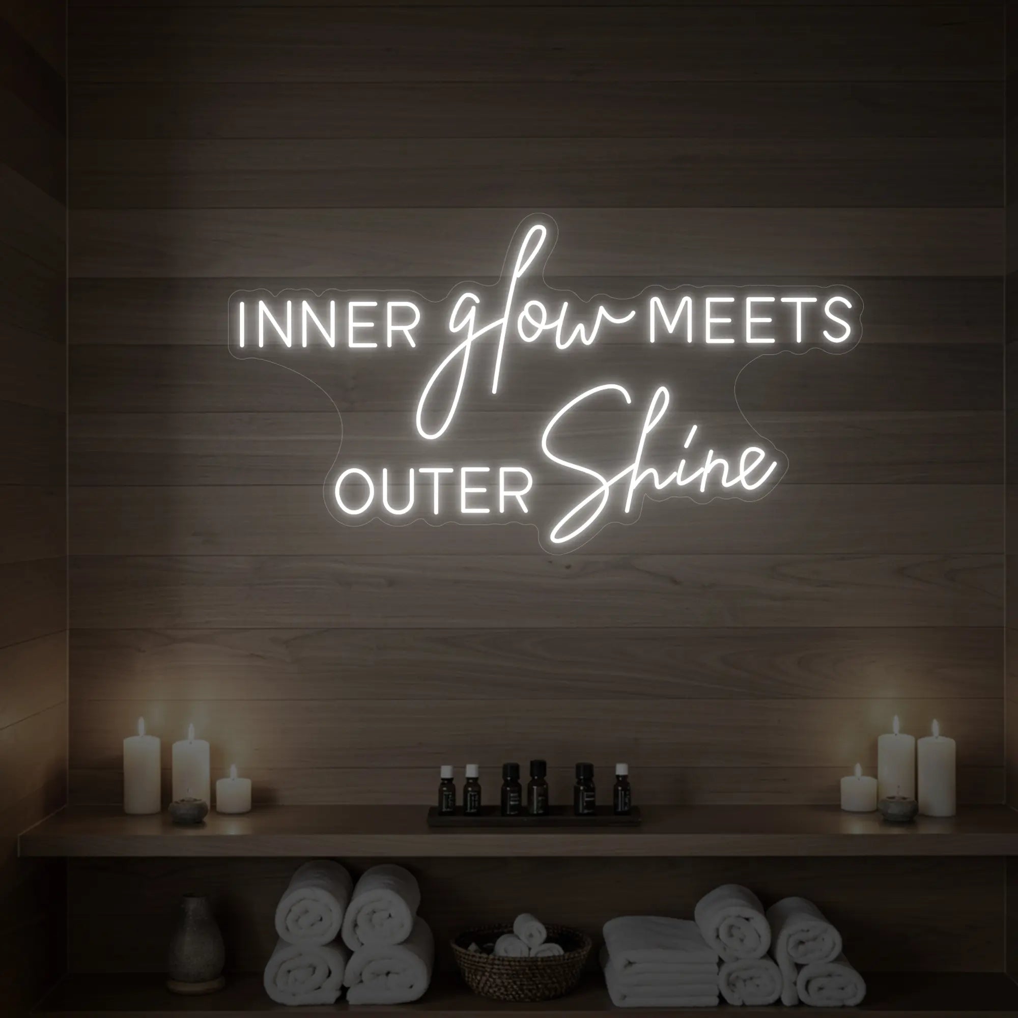 Photo of the 'INNER glow MEETS OUTER Shine' neon sign glowing in cool white against a styled interior wall.