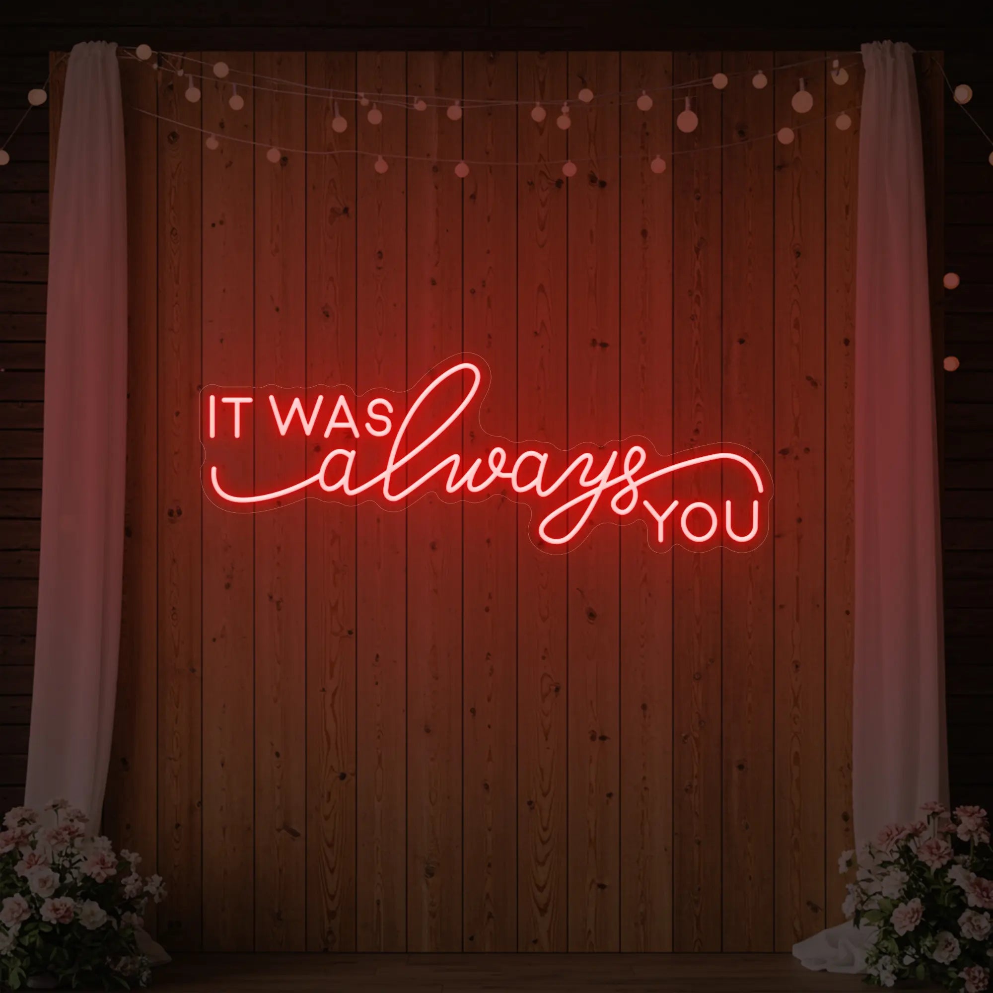 Photo of the 'It Was Always You' neon sign glowing in red against a styled interior wall.