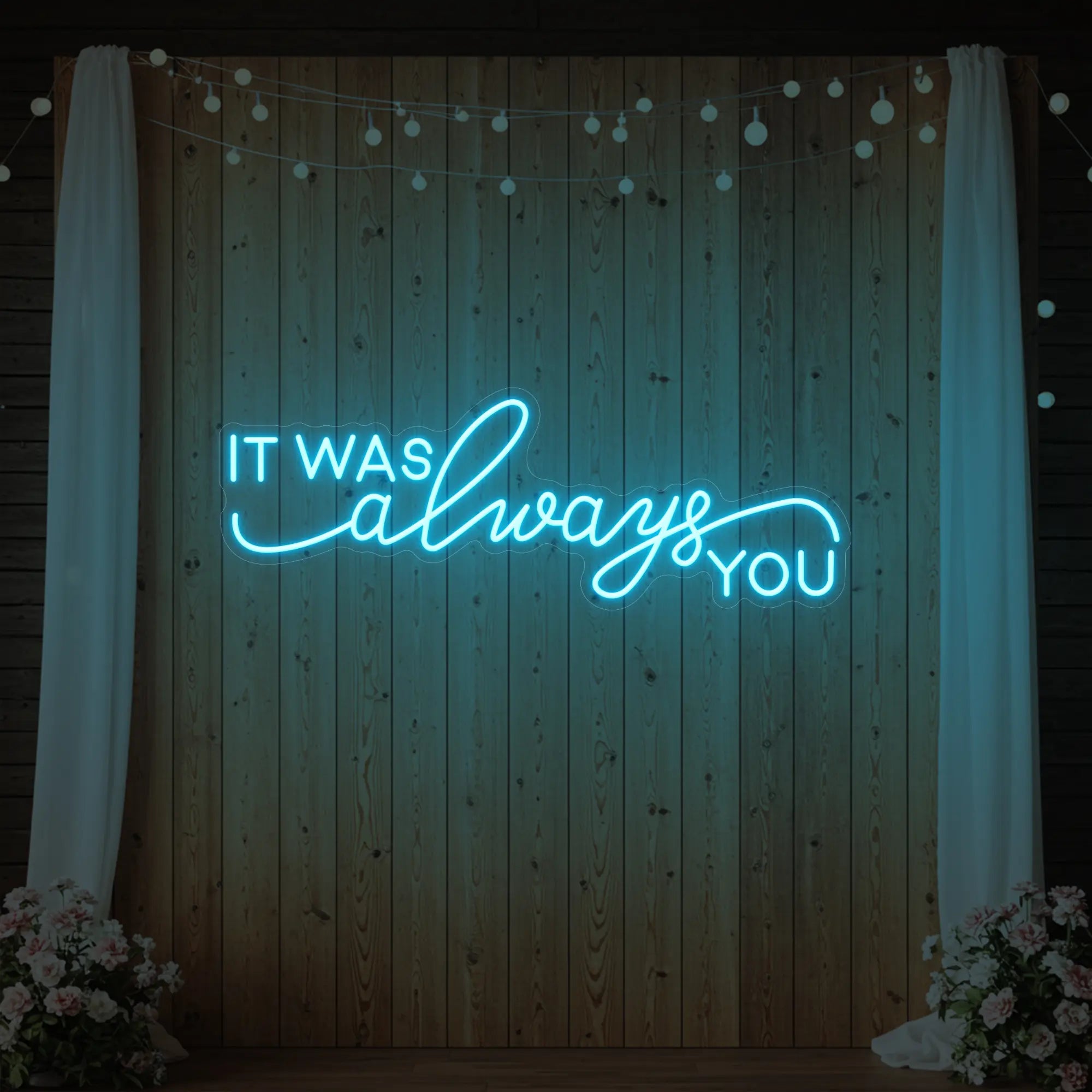 Photo of the 'It Was Always You' neon sign glowing in ice blue against a styled interior wall.