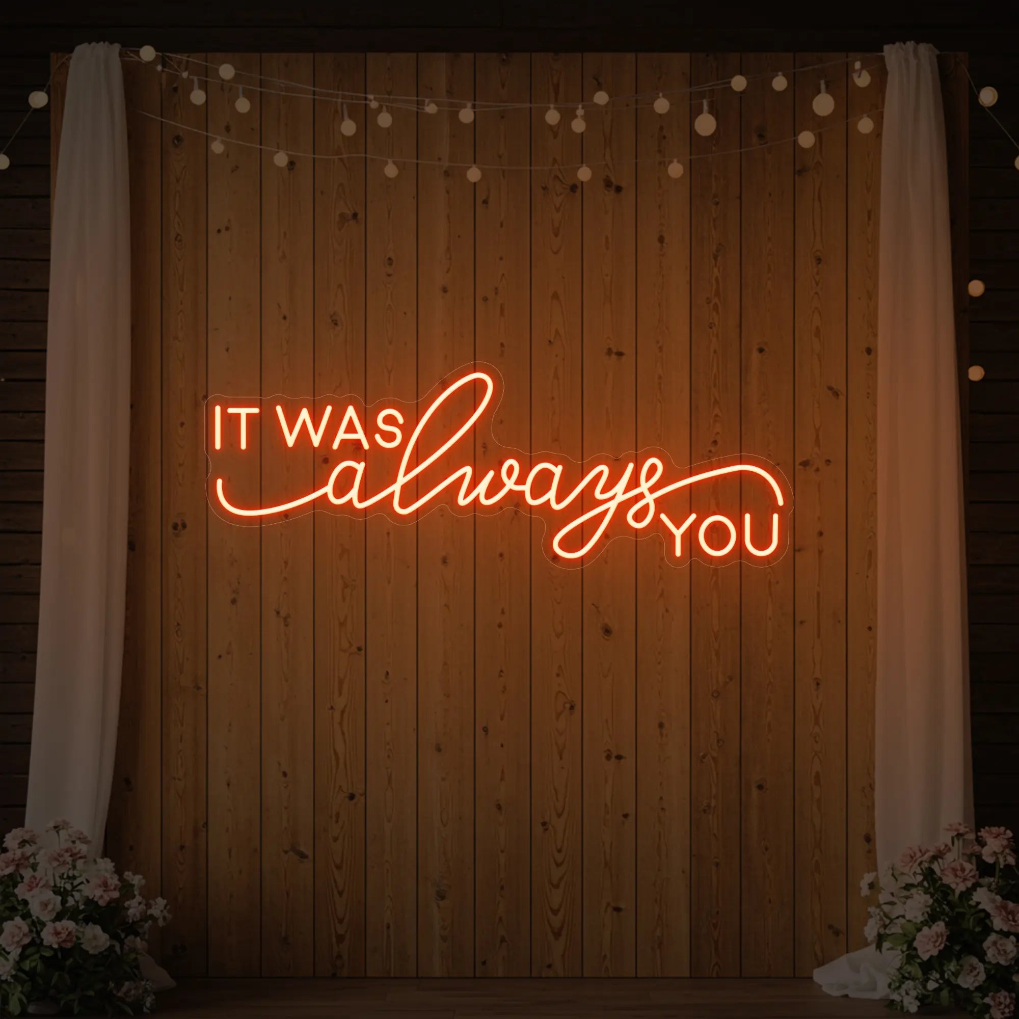Photo of the 'It Was Always You' neon sign glowing in golden yellow against a styled interior wall.
