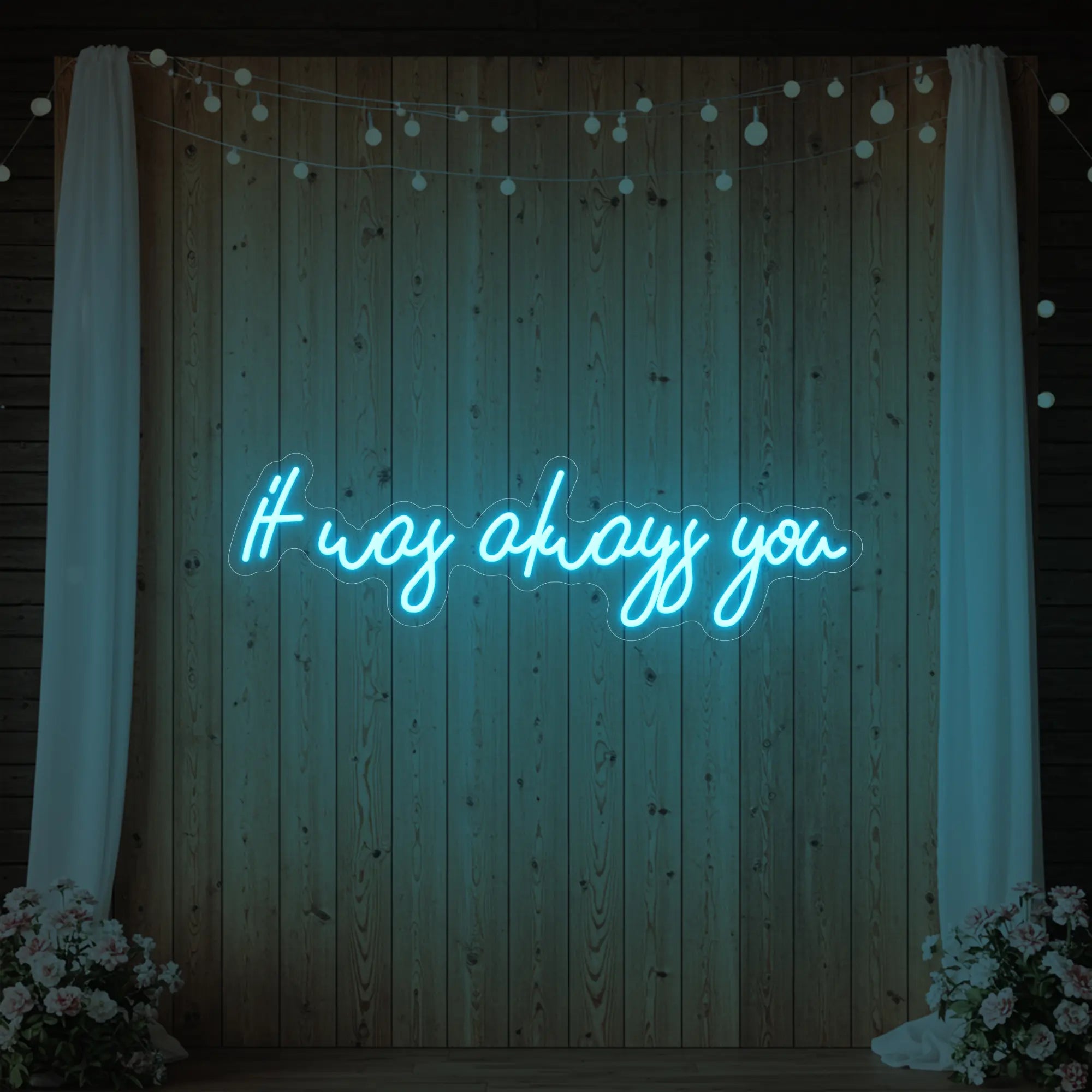 Photo of the 'It Was Always You' neon sign glowing in ice blue against a styled interior wall.