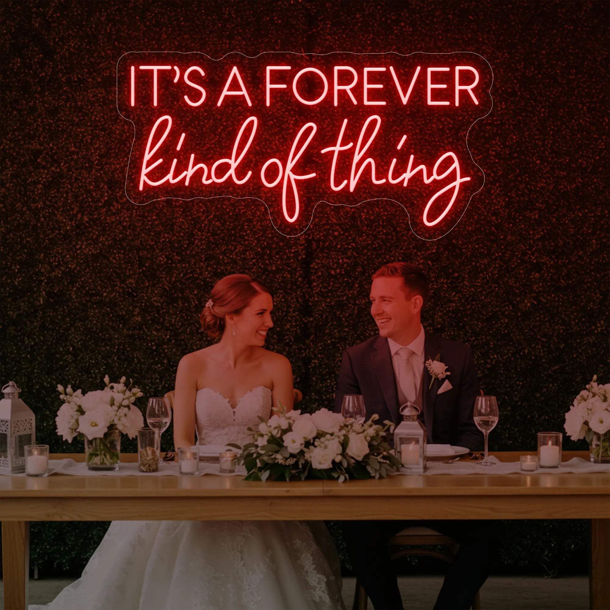 Photo of the 'It’s a Forever Kind of Thing' neon sign glowing in red against a styled interior wall.