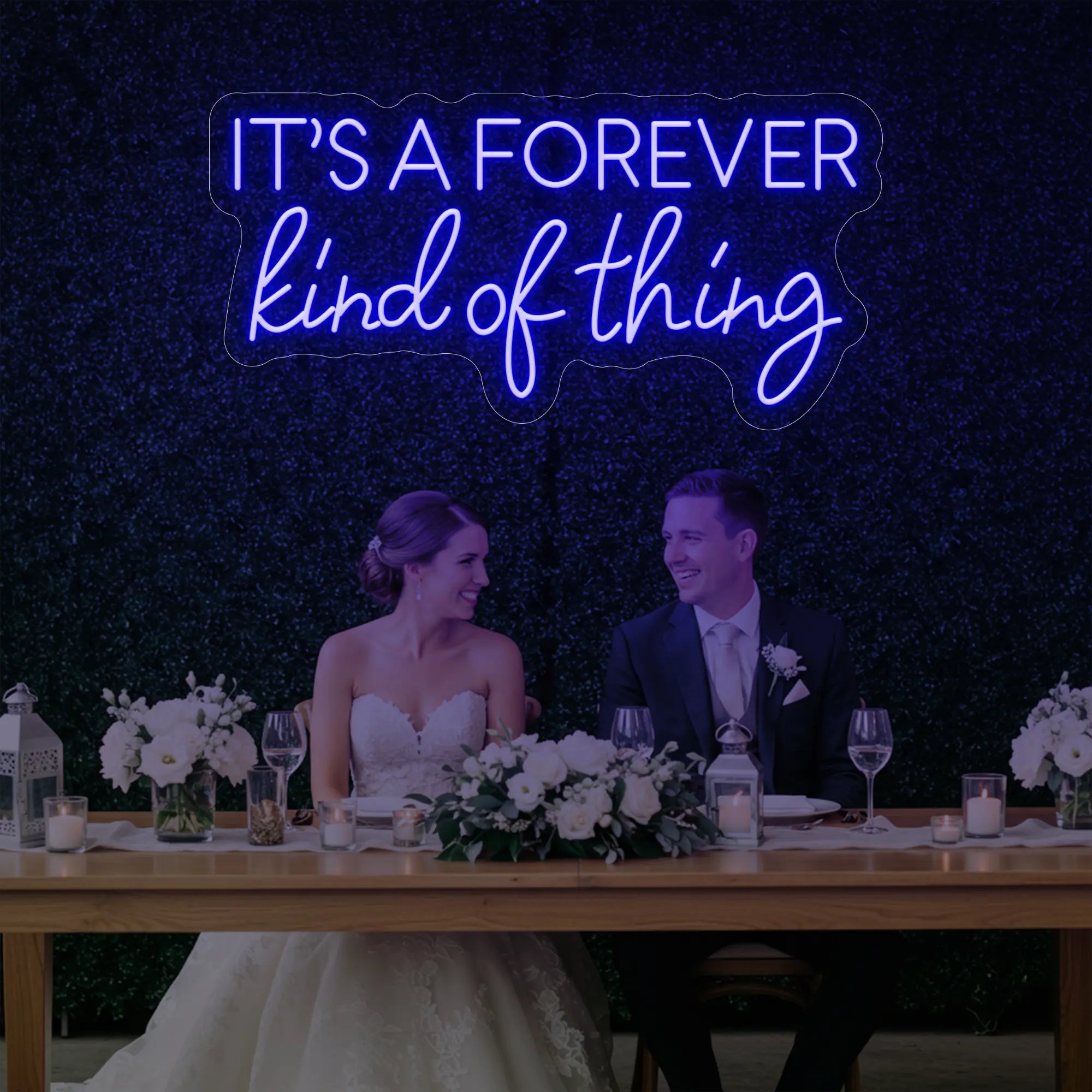 Photo of the 'It’s a Forever Kind of Thing' neon sign glowing in deep blue against a styled interior wall.
