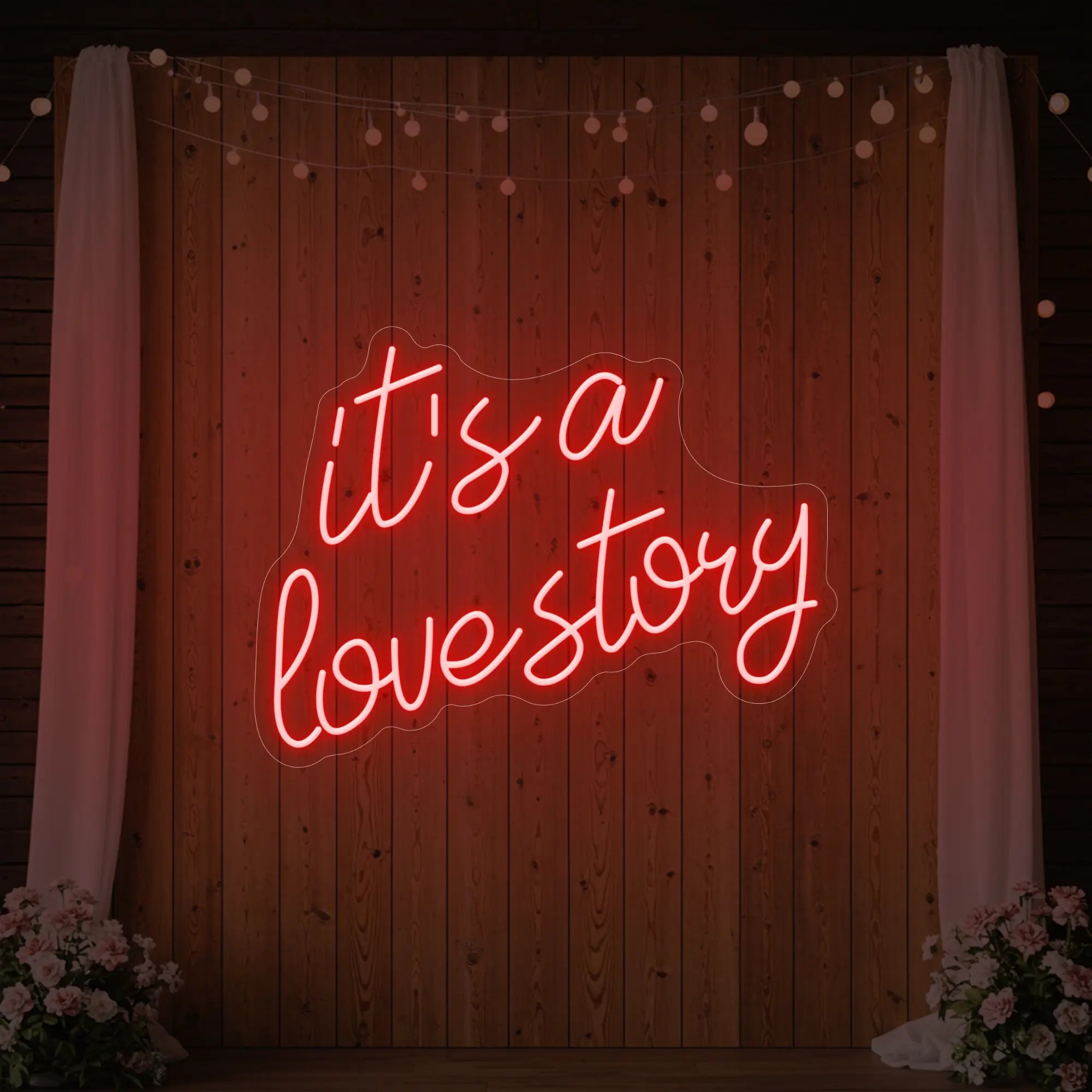 Photo of the 'It’s a Love Story' neon sign glowing in red against a styled interior wall.