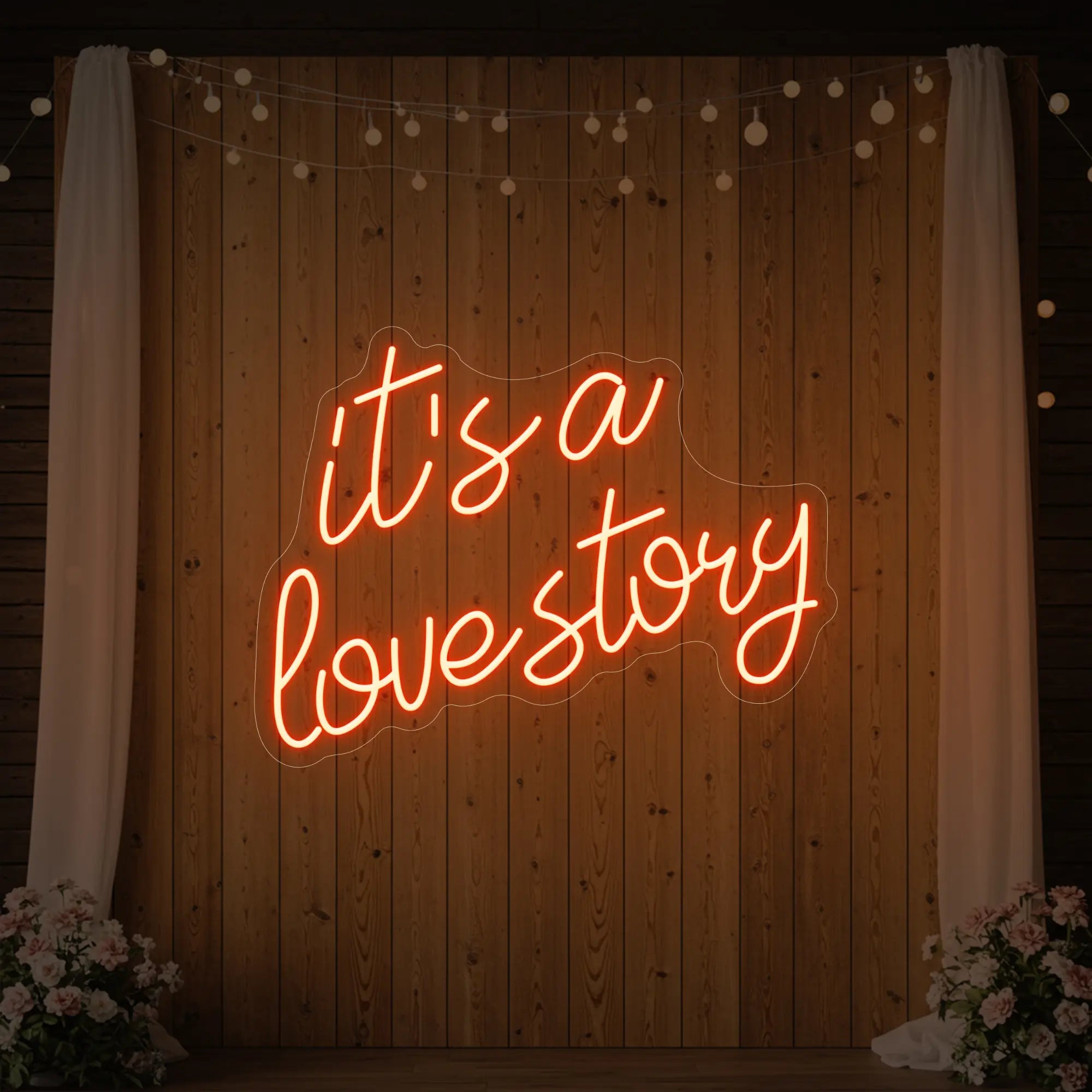 Photo of the 'It’s a Love Story' neon sign glowing in golden yellow against a styled interior wall.