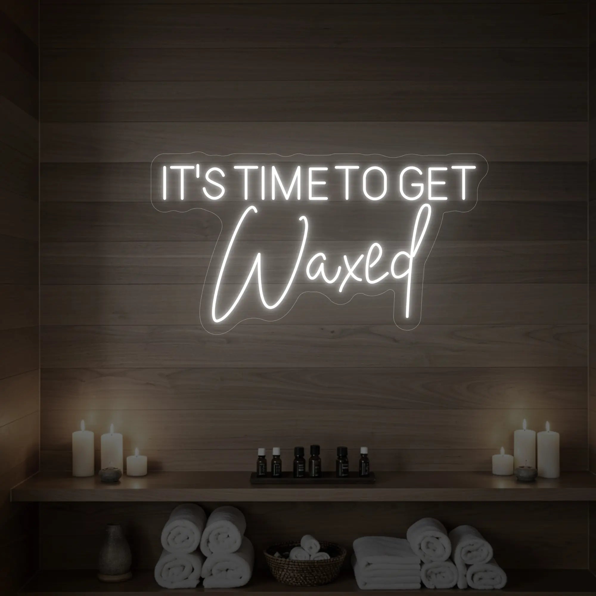 Photo of the 'IT’S TIME TO GET Waxed' neon sign glowing in cool white against a styled interior wall.