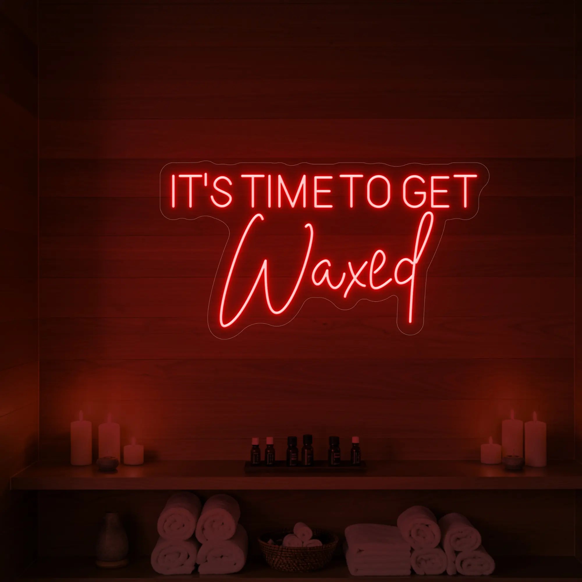 Photo of the 'IT’S TIME TO GET Waxed' neon sign glowing in red against a styled interior wall.