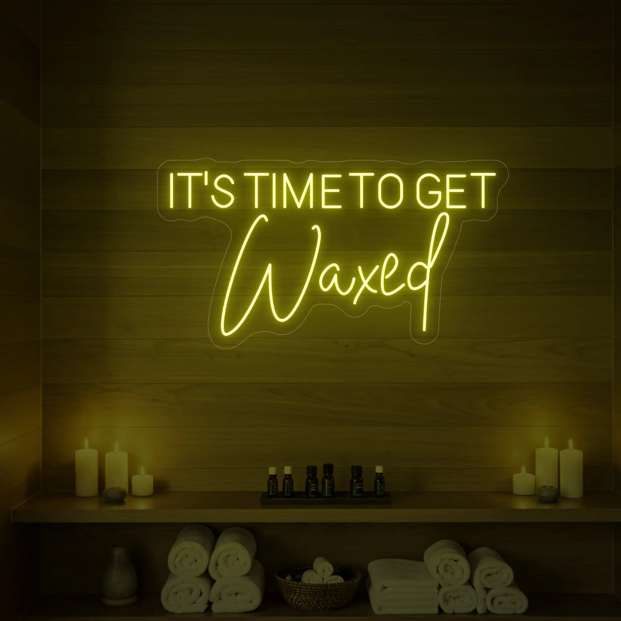 Photo of the 'IT’S TIME TO GET Waxed' neon sign glowing in lemon yellow against a styled interior wall.
