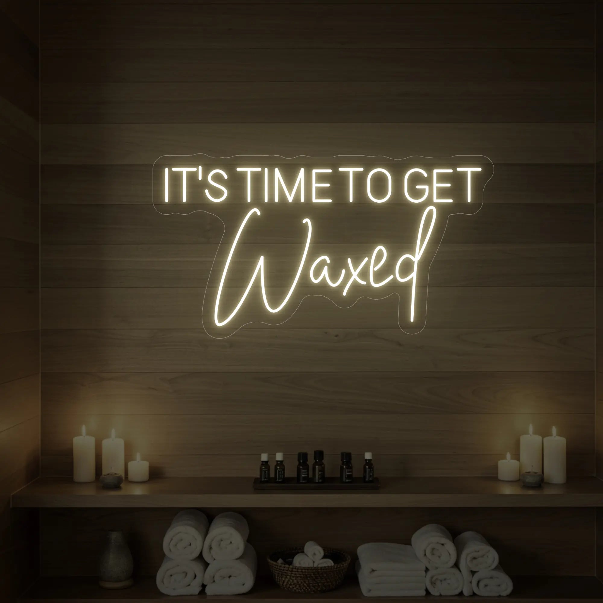 Photo of the 'IT’S TIME TO GET Waxed' neon sign glowing in warm white against a styled interior wall.