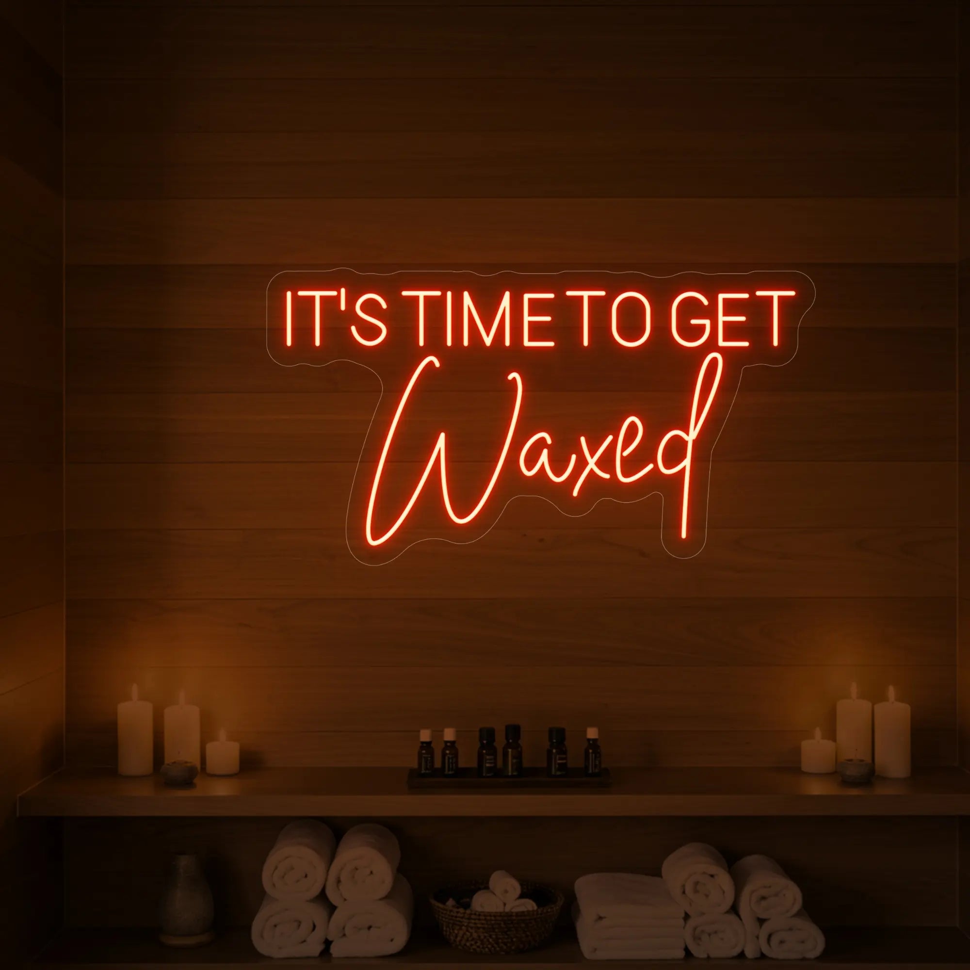 Photo of the 'IT’S TIME TO GET Waxed' neon sign glowing in golden yellow against a styled interior wall.