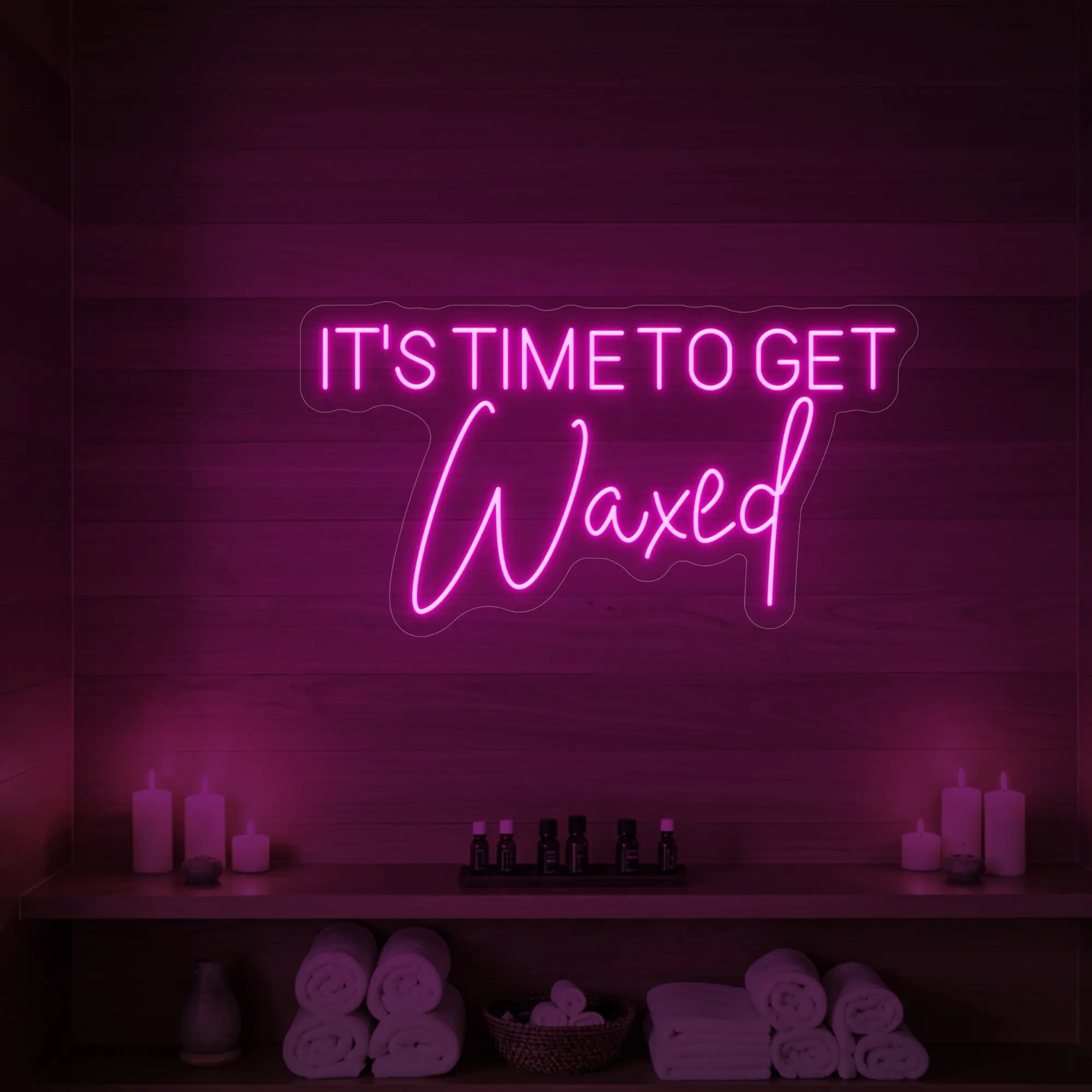 Photo of the 'IT’S TIME TO GET Waxed' neon sign glowing in light pink against a styled interior wall.