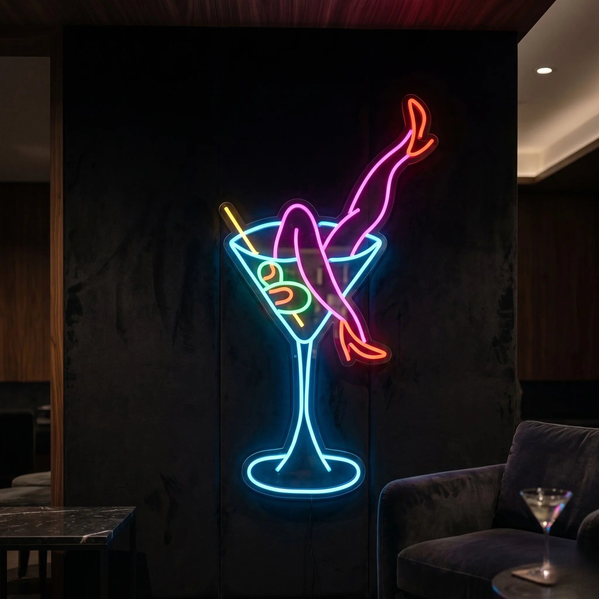 Photo of the martini legs neon sign glowing in multi-color against a styled interior wall.